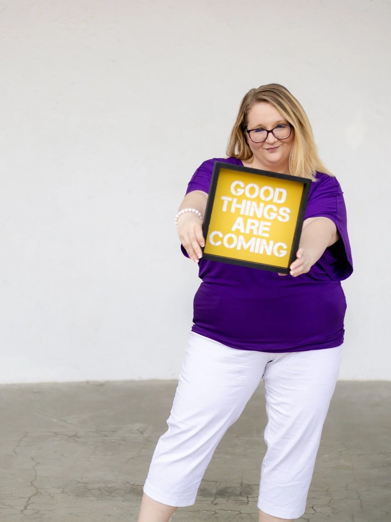 Female entrepreneur holding encouraging sign saying good things are coming