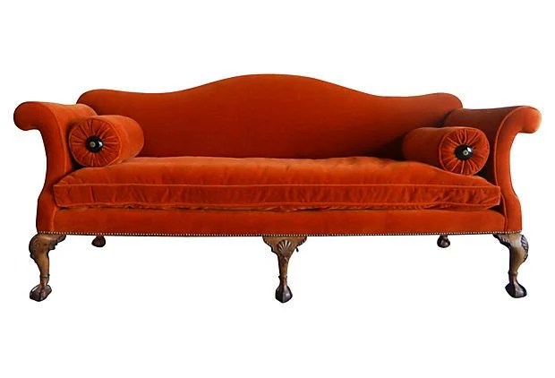 A curvy Chippendale sofa showing s-curves, cabriole leg and ball and claw foot.