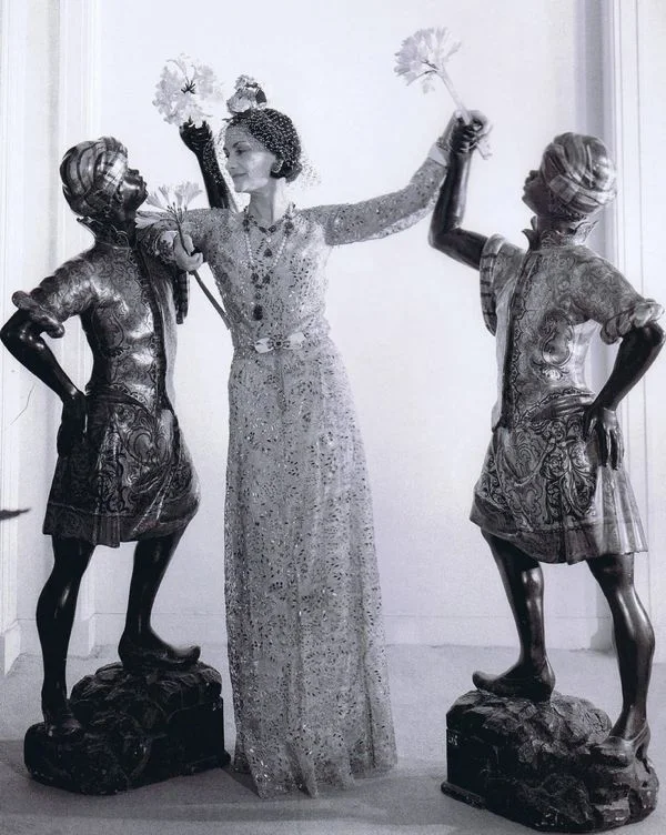 Coco Chanel with a pair of Blackamoor scuplture