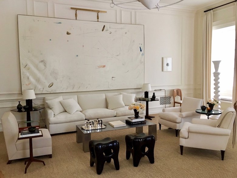 Alyssa Kapito's all white living room for Holiday House NYC 2017 features a large painting by William McClure