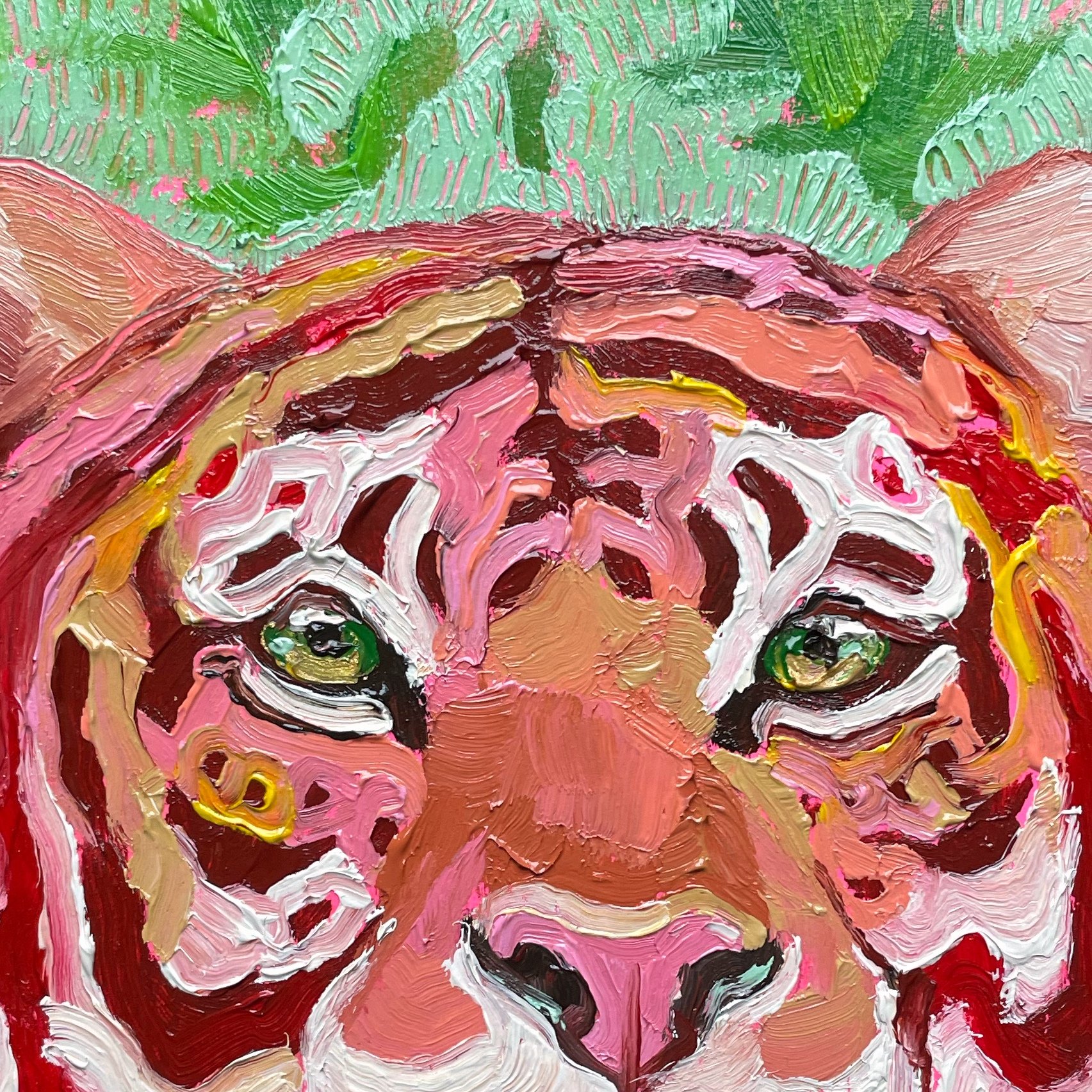 a close up on a colorful painting of a tiger against a green leafy background