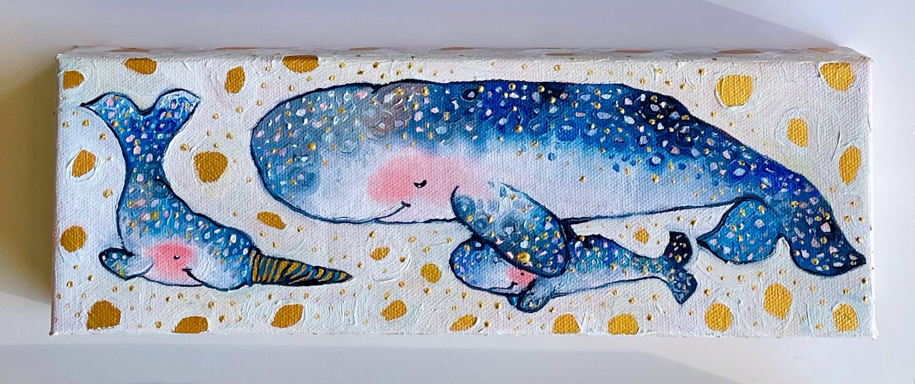 a painting of three narwhals, one adult and two babies, against a white background