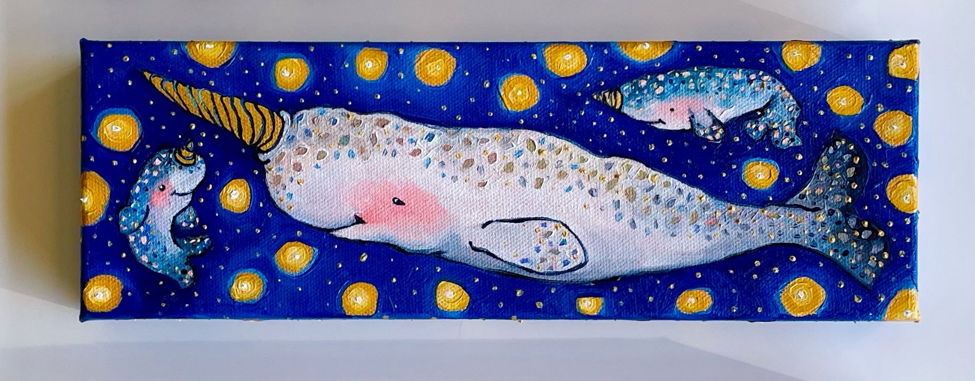 a painting of three narwhals, one adult and two babies, against a blue background