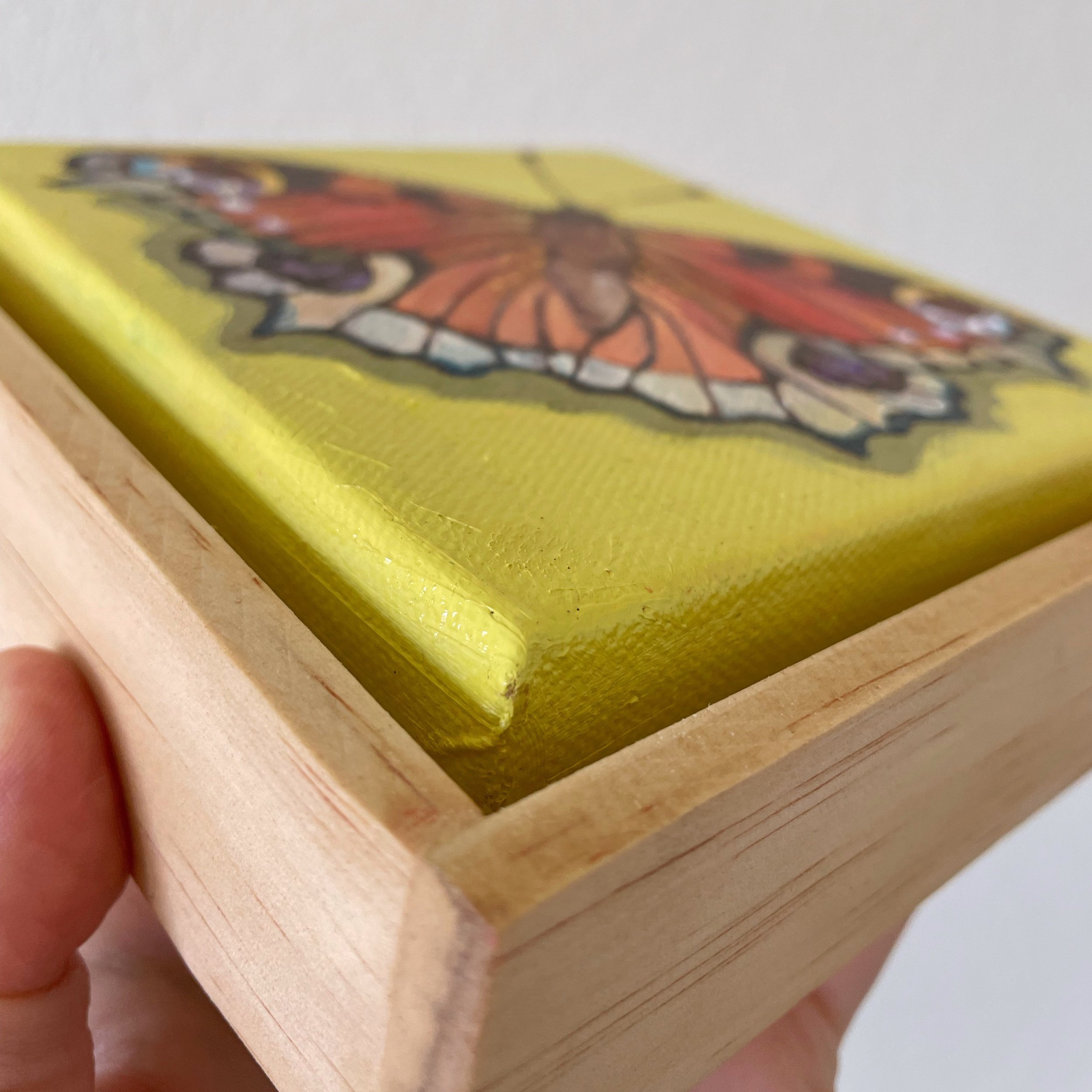 A low side angle focused on the frame of the peacock butterfly painting