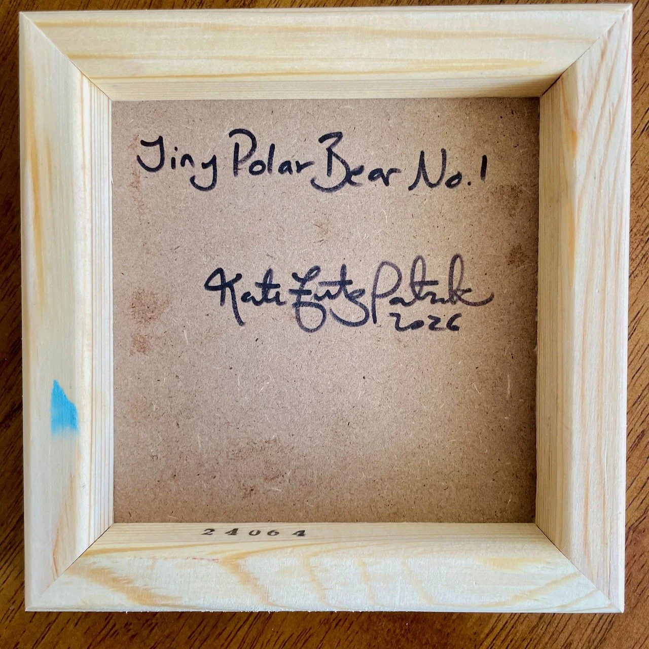 the back of the cradled wood canvas with writing that says tiny polar bear no.1 kate fitzpatrick 2026