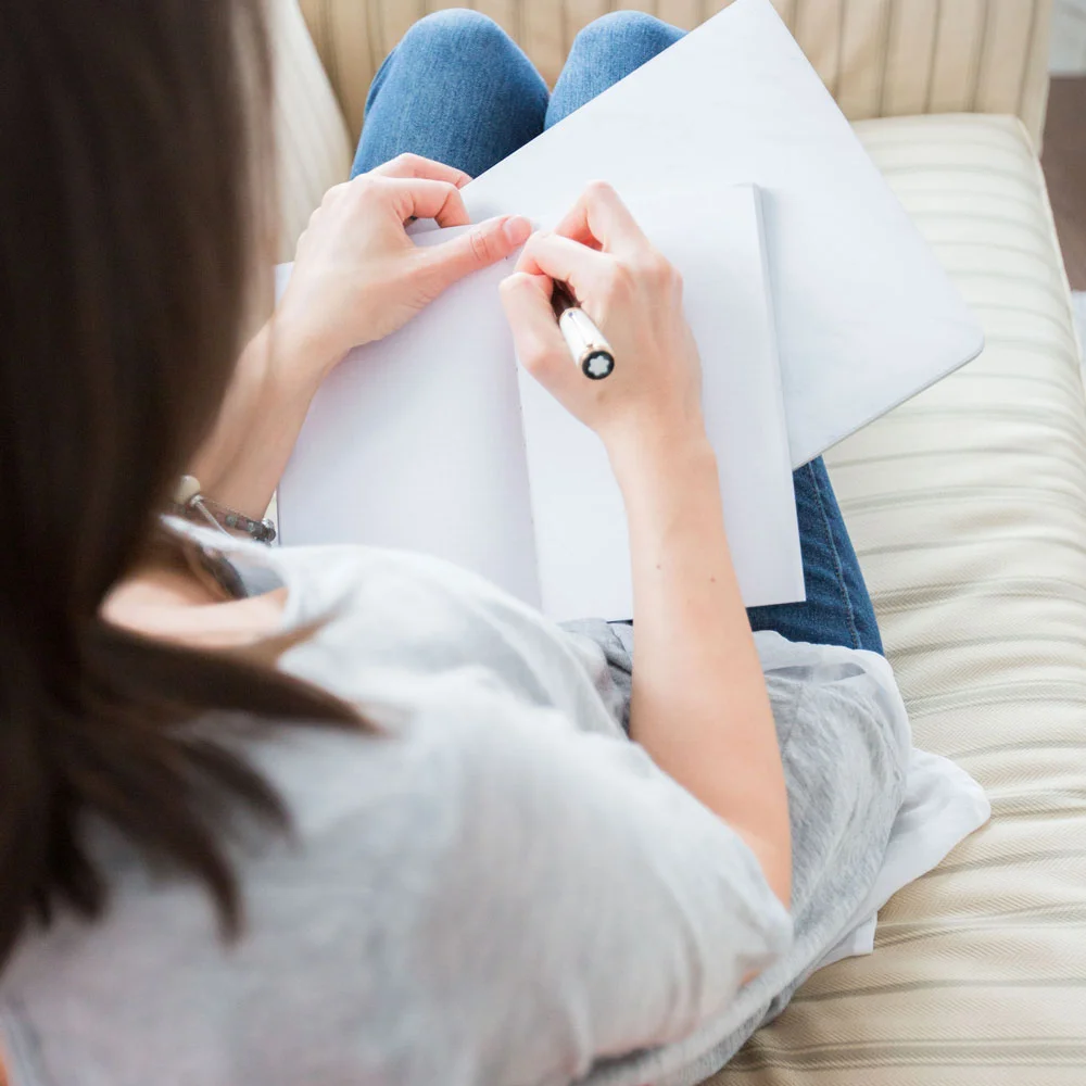 woman-writing-financial-notes-in-notebook.jpg