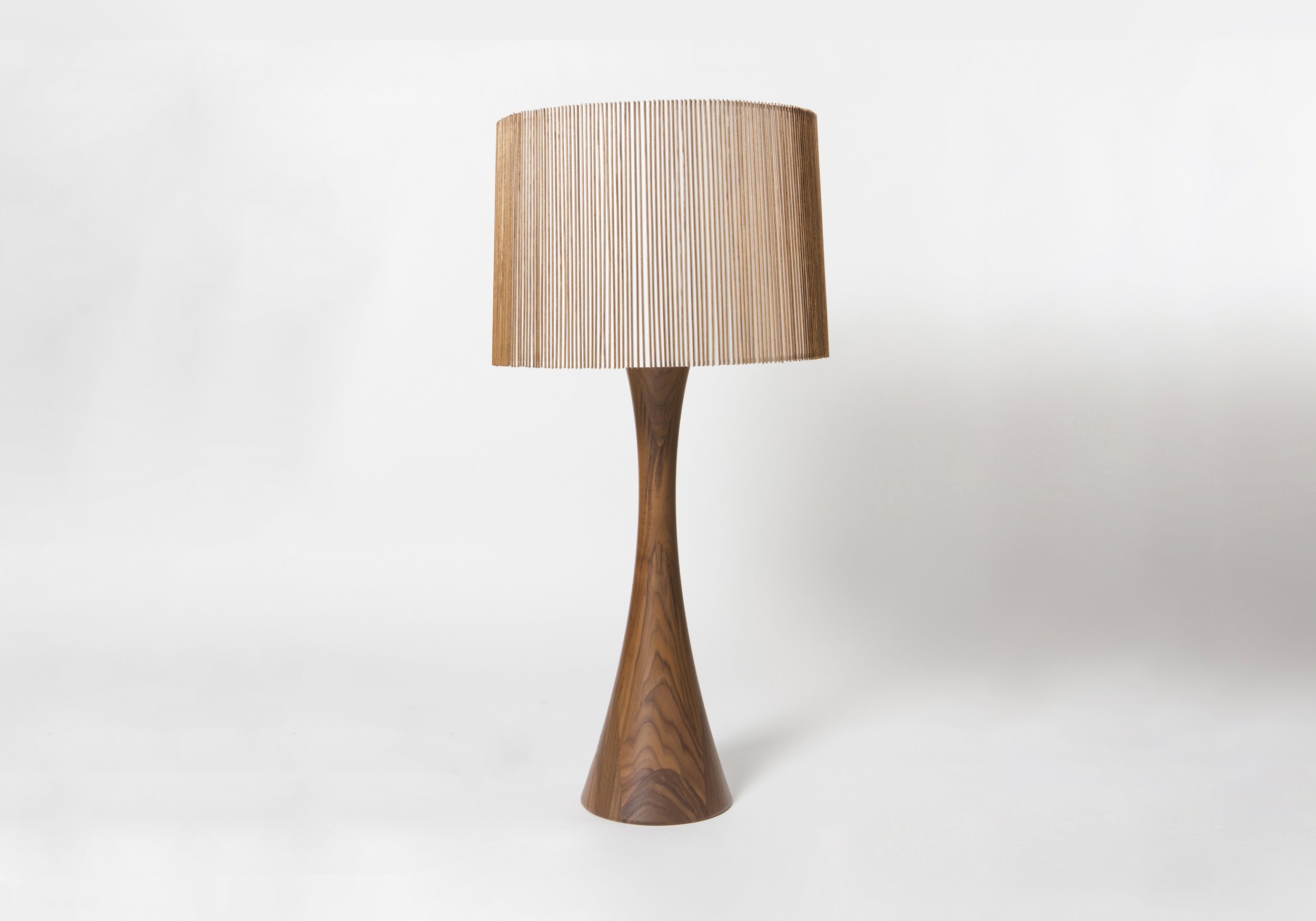 Wooden table lamp with a textured beige lampshade on a white background designed by Mel Smilow