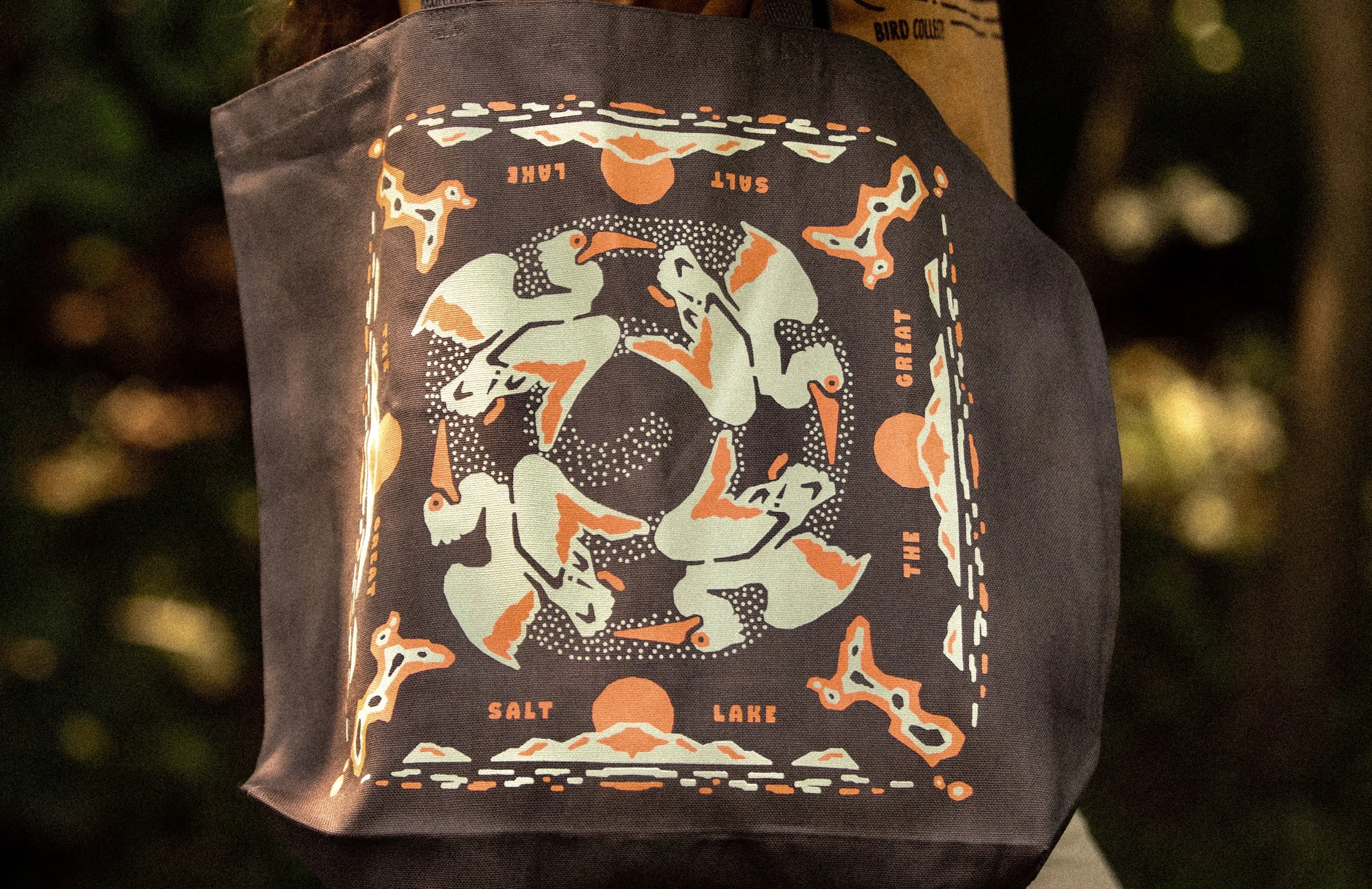 Close-up of American White Pelican and Spiral Jetty illustration on screen printed Bird Collective tote