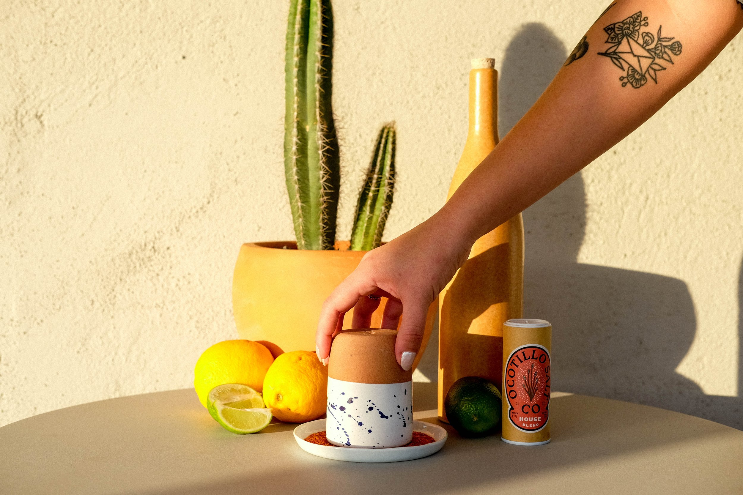 Hand dipping cup in Ocotillo Salt Co spices featuring branding and packaging design