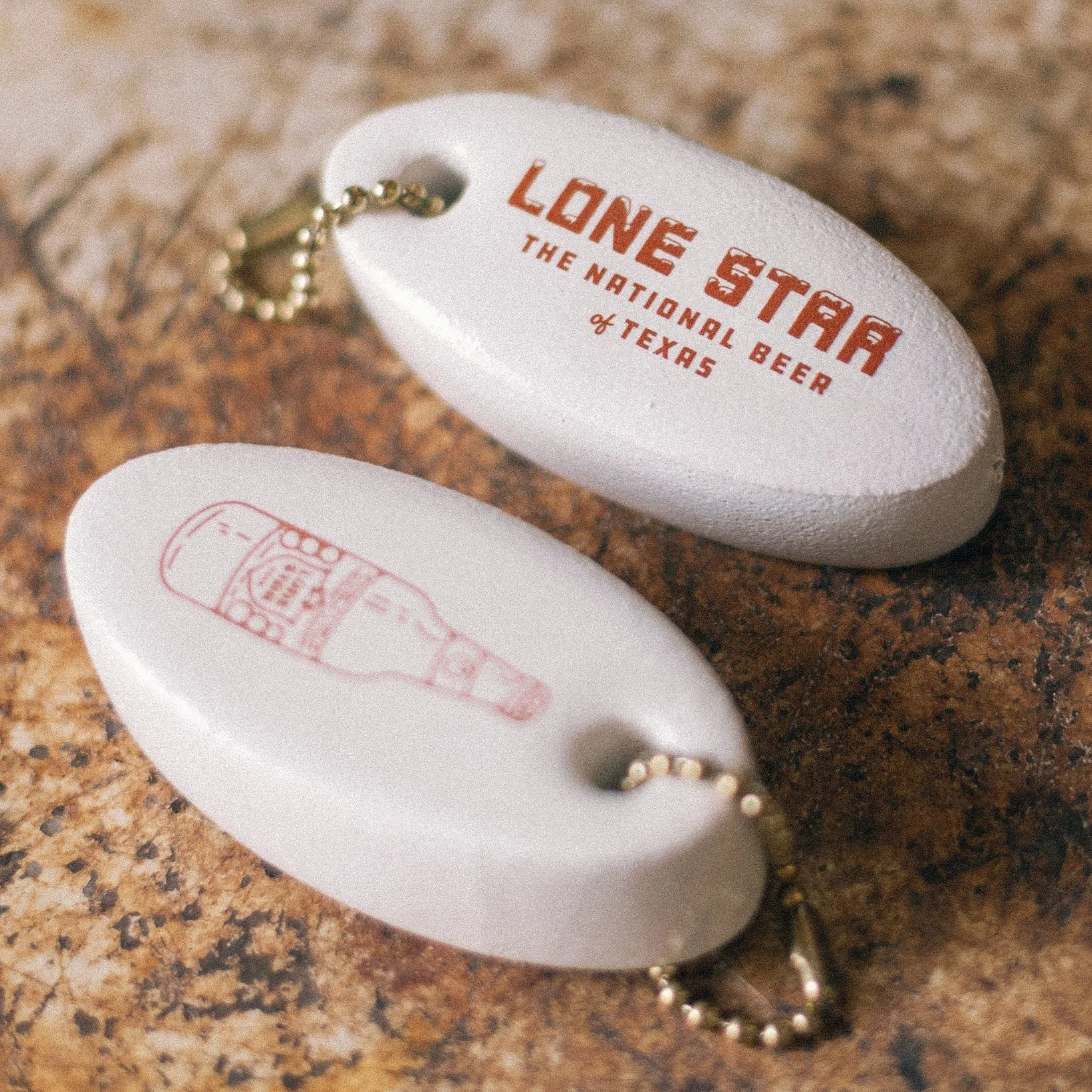 Vintage puffy floaty keychain design with ice letters and tagline design detail for Lone Star Beer