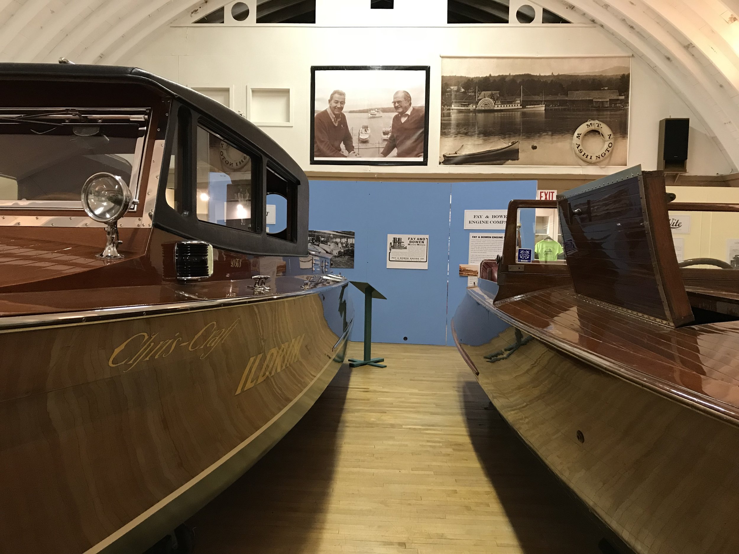 Two beautiful wooden boats on display.