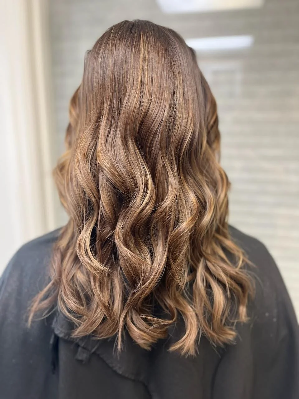 Dimensional brunette hair color with warm caramel tones at Salon Sonik