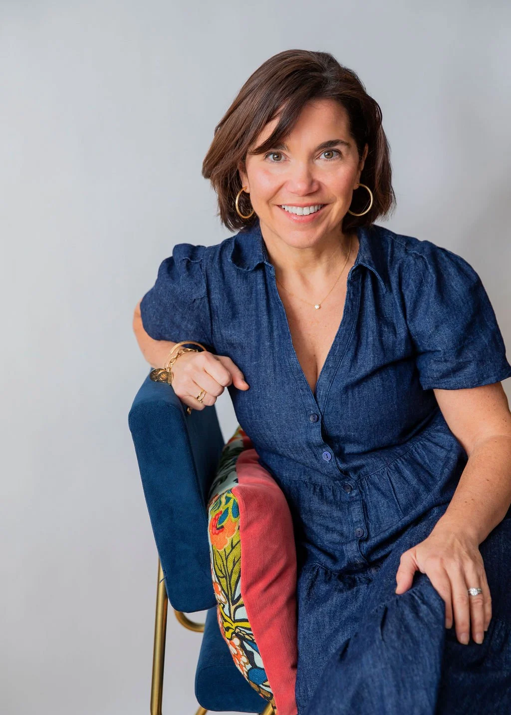 smiling woman wearing a blue dress and smiling at the camera