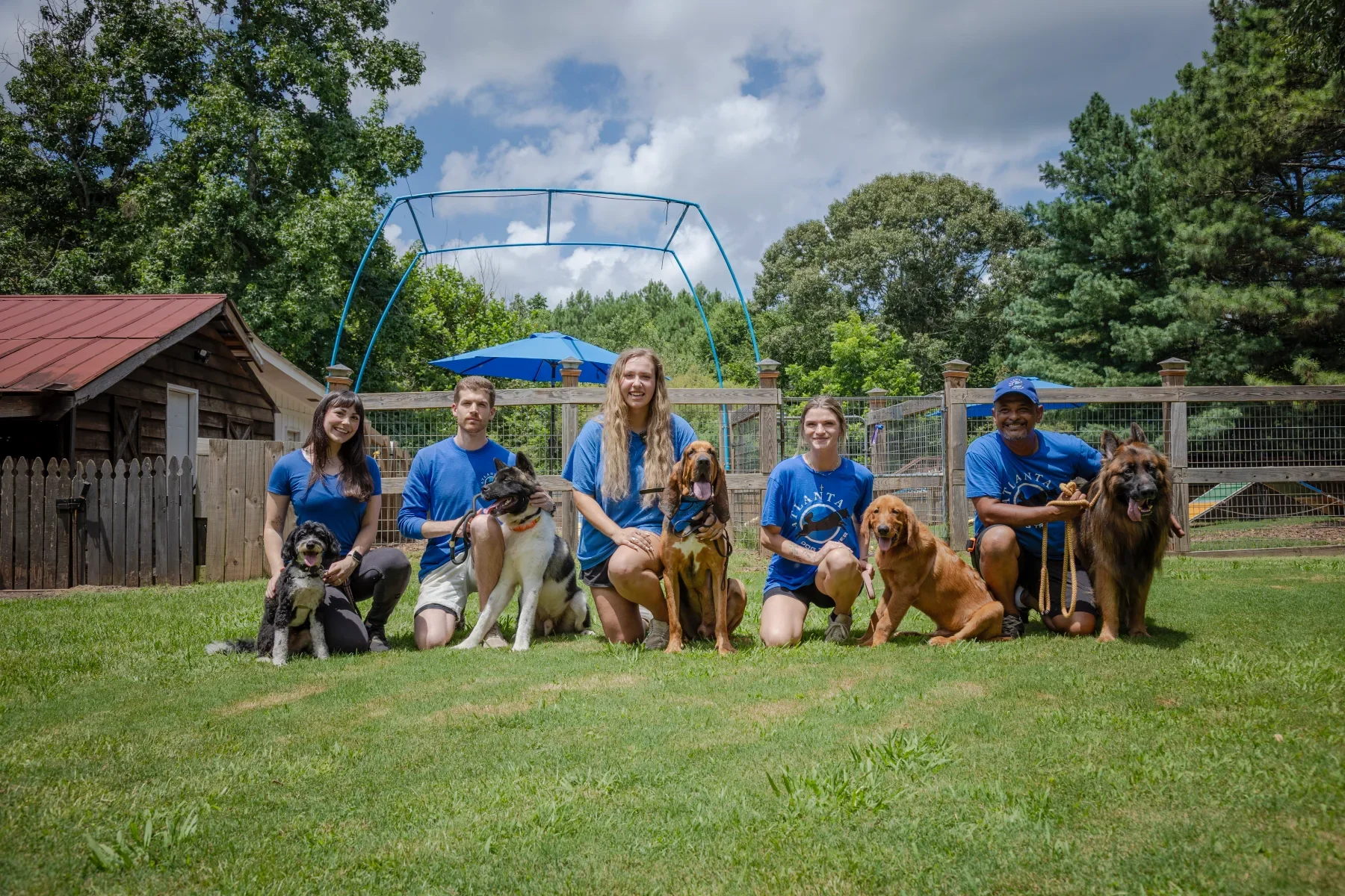 Trainers posing with dogs at Atlanta Dog Trainer Milton farm