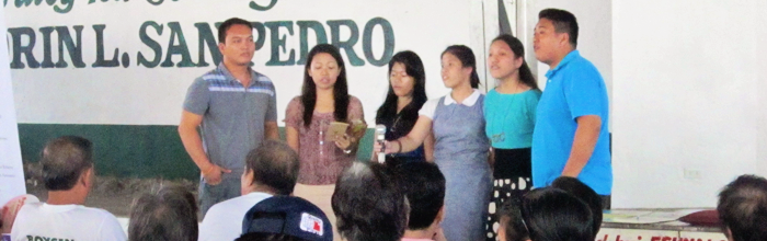 Pastor Spencer (rightmost) leads accapela singers in a number for the seniors.