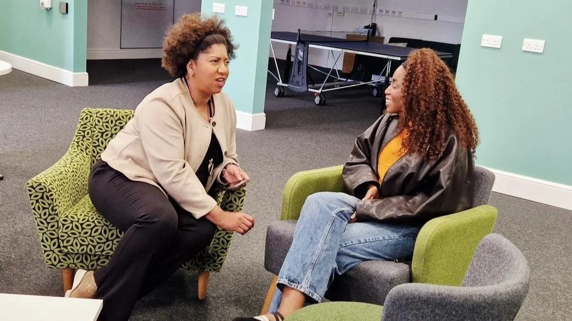 Leadership coach supporting an emerging leader through a one-to-one coaching conversation during a leadership development programme.