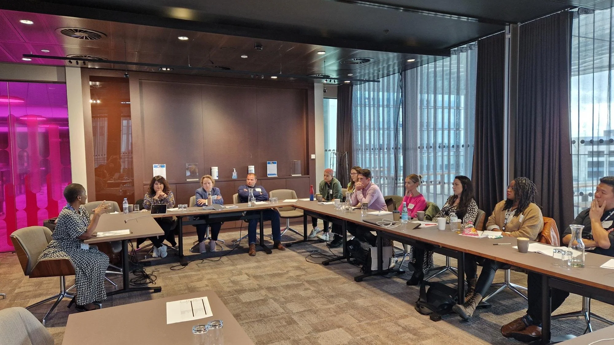 Leadership facilitator delivering an emerging leaders development workshop to a diverse group of professionals in a corporate training environment.