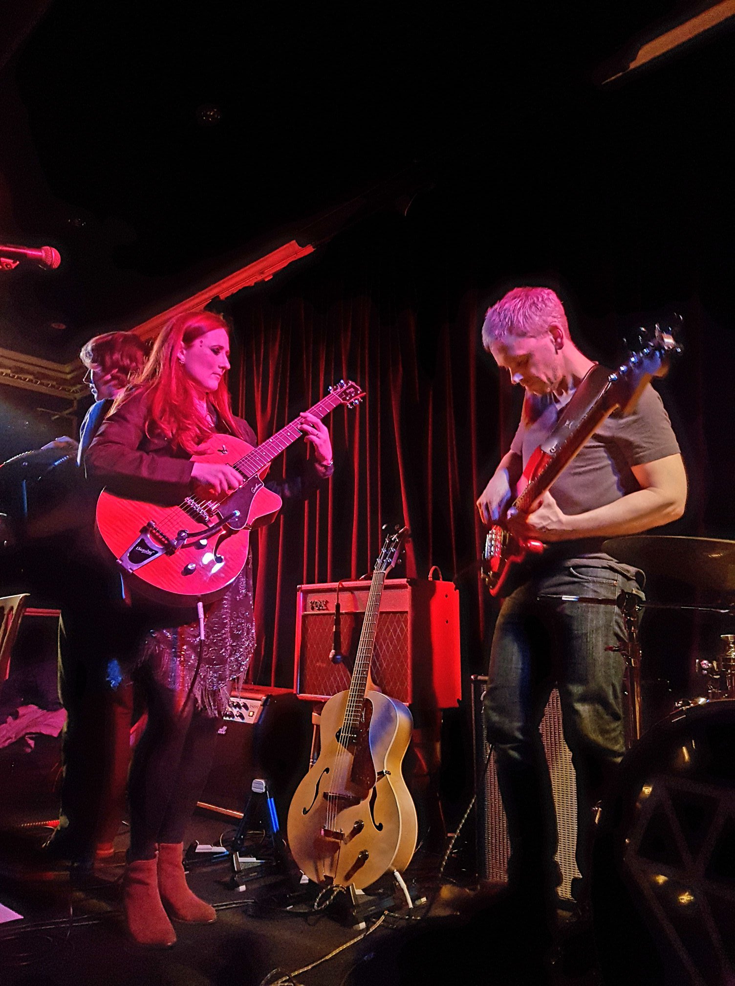 A rock band performing live on stage with stage lights.