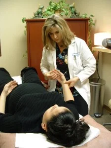 Kristen Burris performing acupuncture on young woman