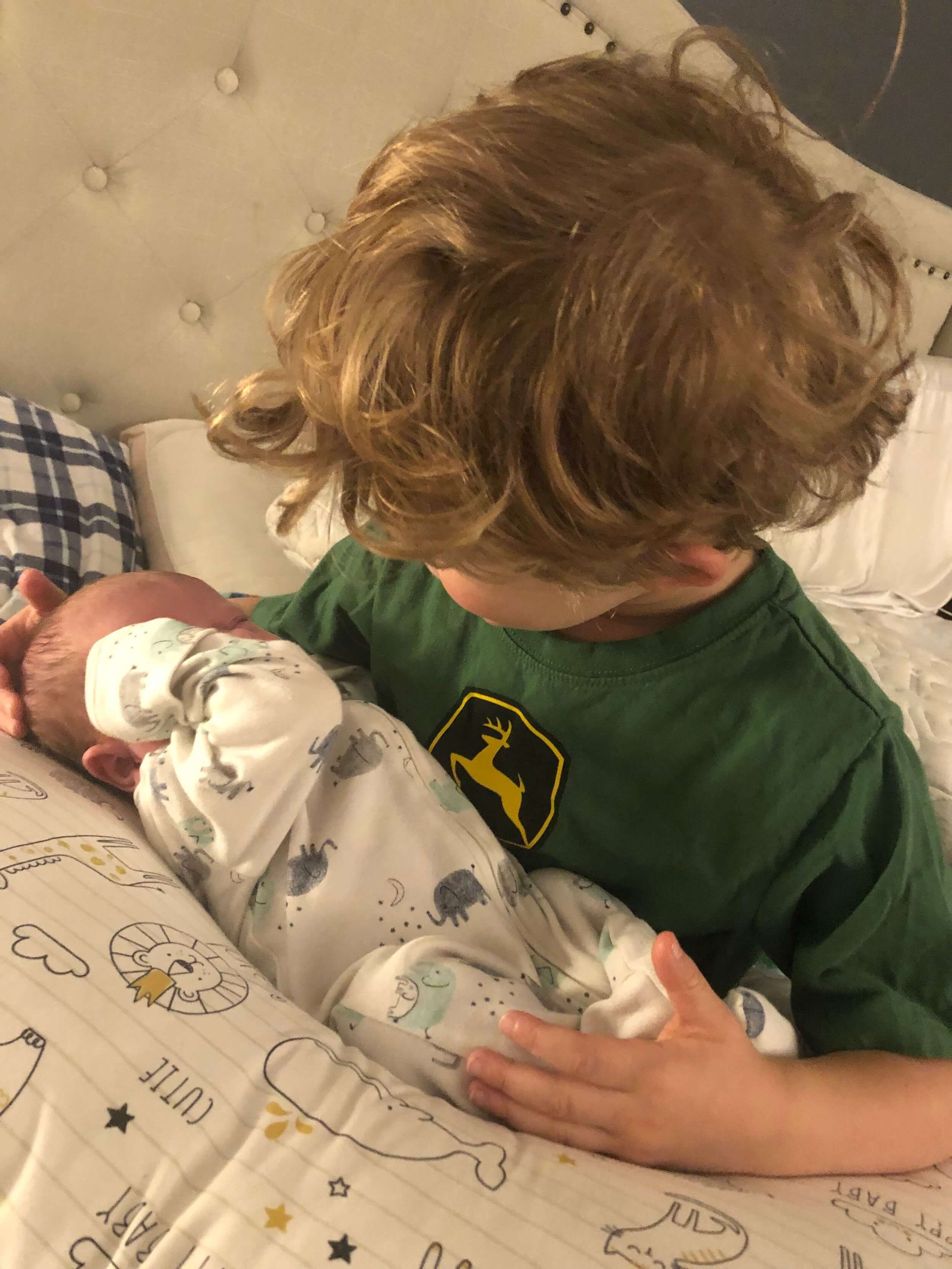 young boy holding his baby brother