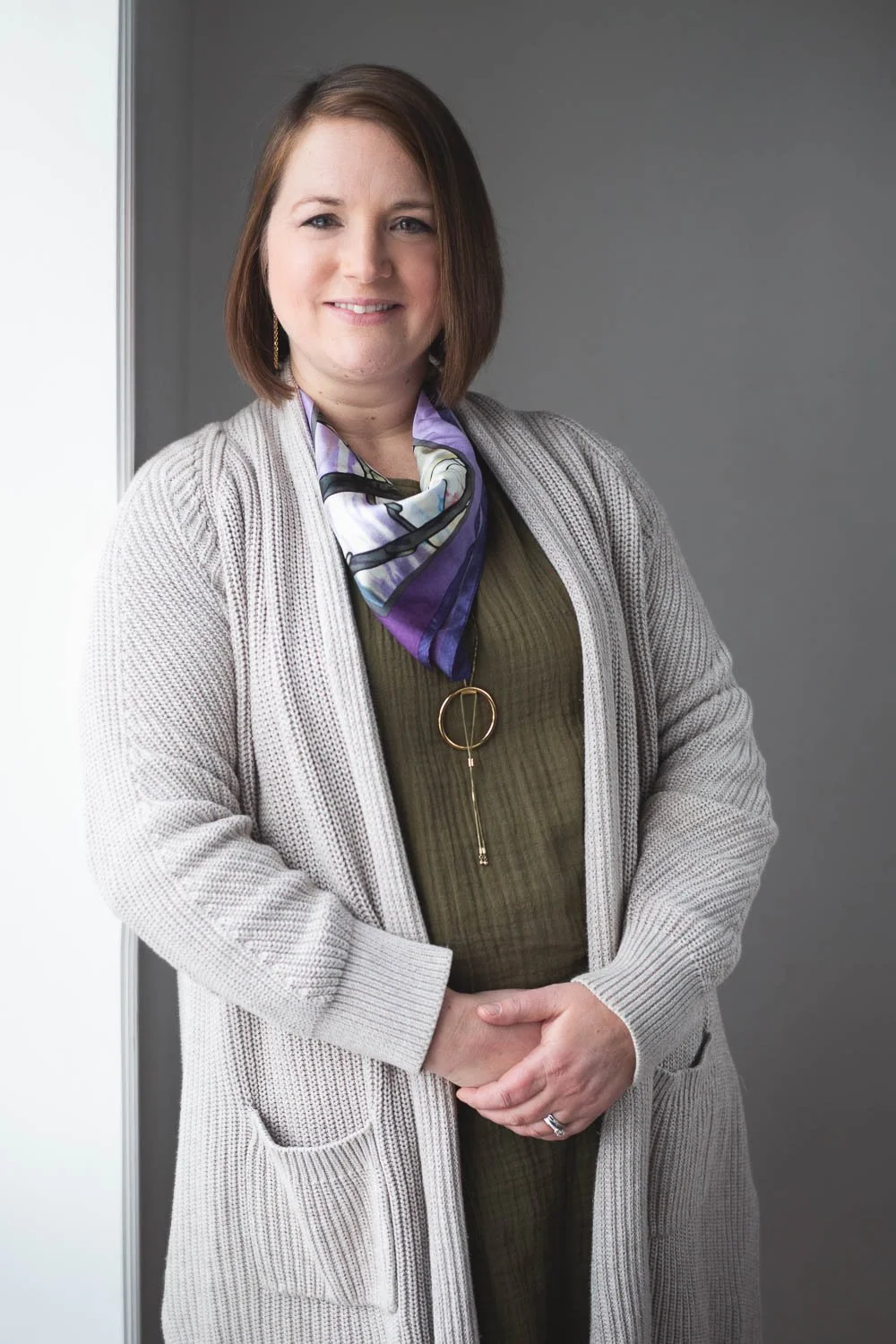 Marna in beige sweater and purple scarf