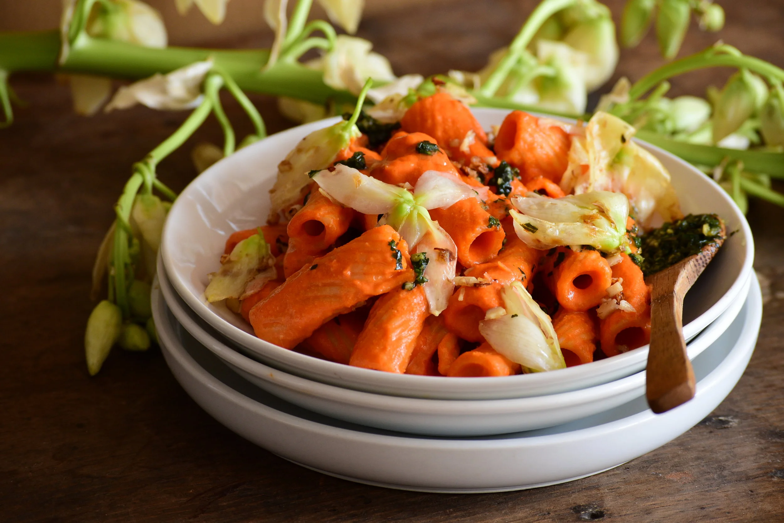 Rigatoni con crema de chiles rostizados, pistou de albahaca, y flores de izote