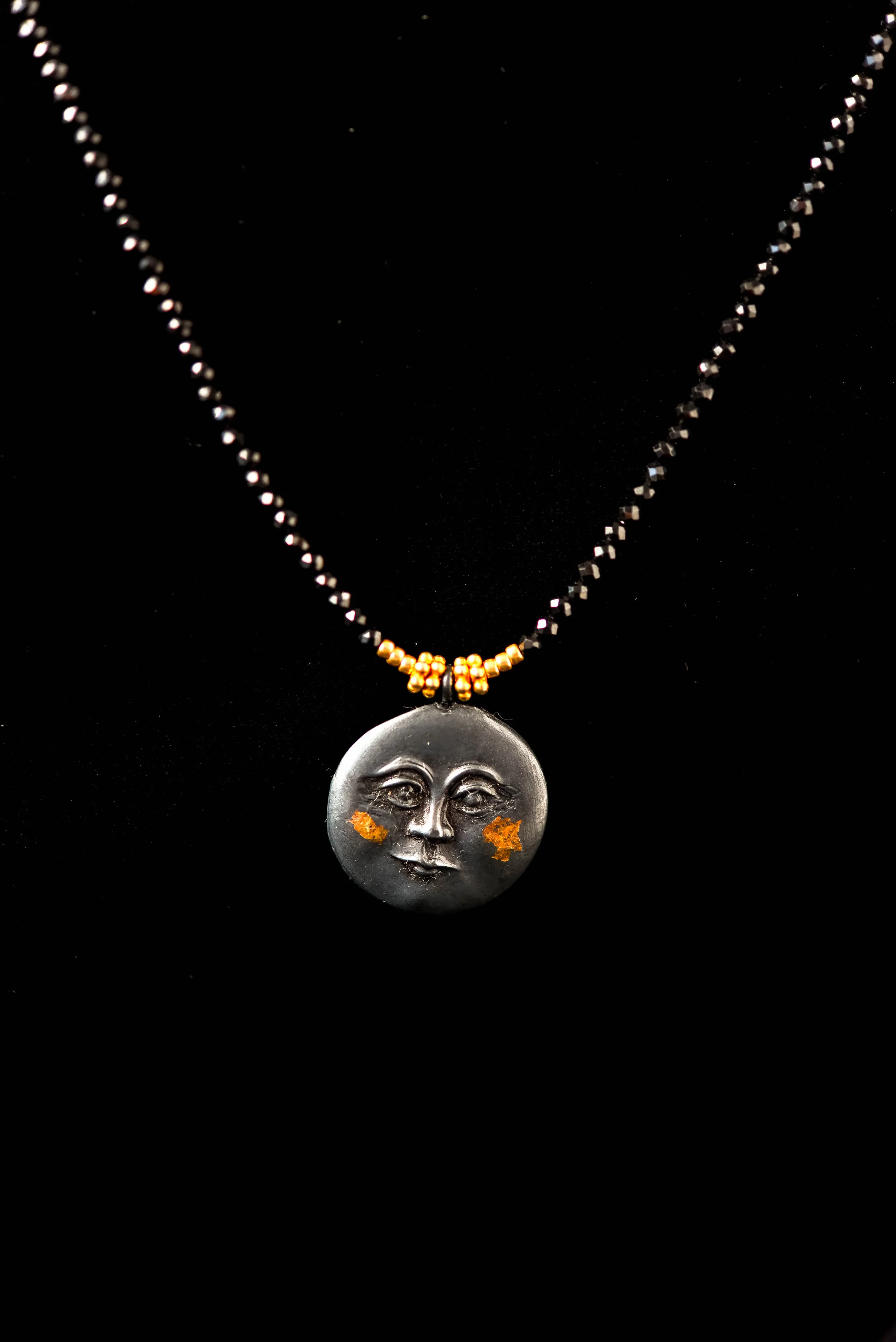 Oxidized Fine Silver Mr. Moon with 24K gold cheeks. Available in 2mm Micro faceted Black Spinel or