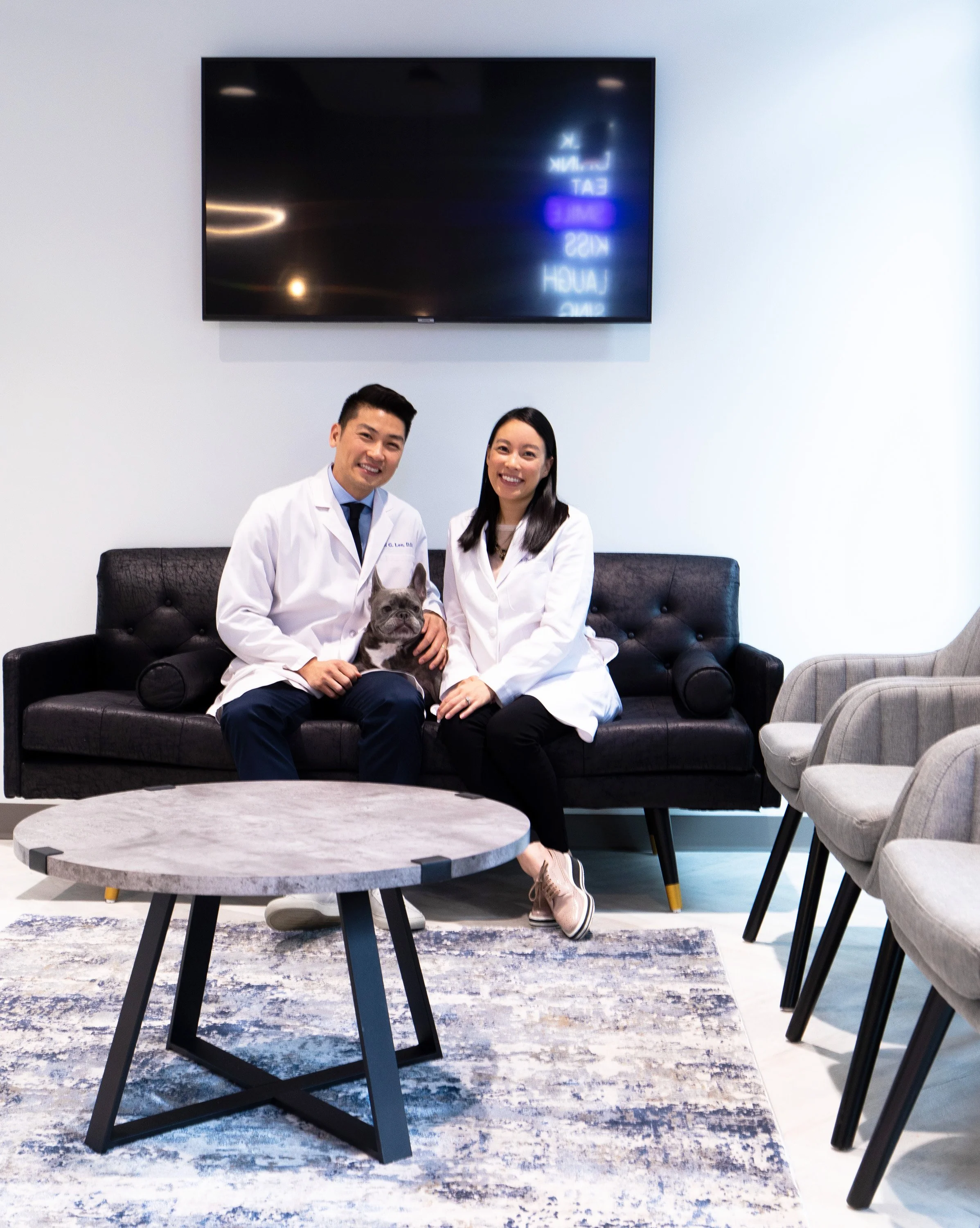 Drs. Daniel Lee, Christina Lee, and Alina Tran with the practice's French bulldog at The Smile Space in Belltown, Seattle.