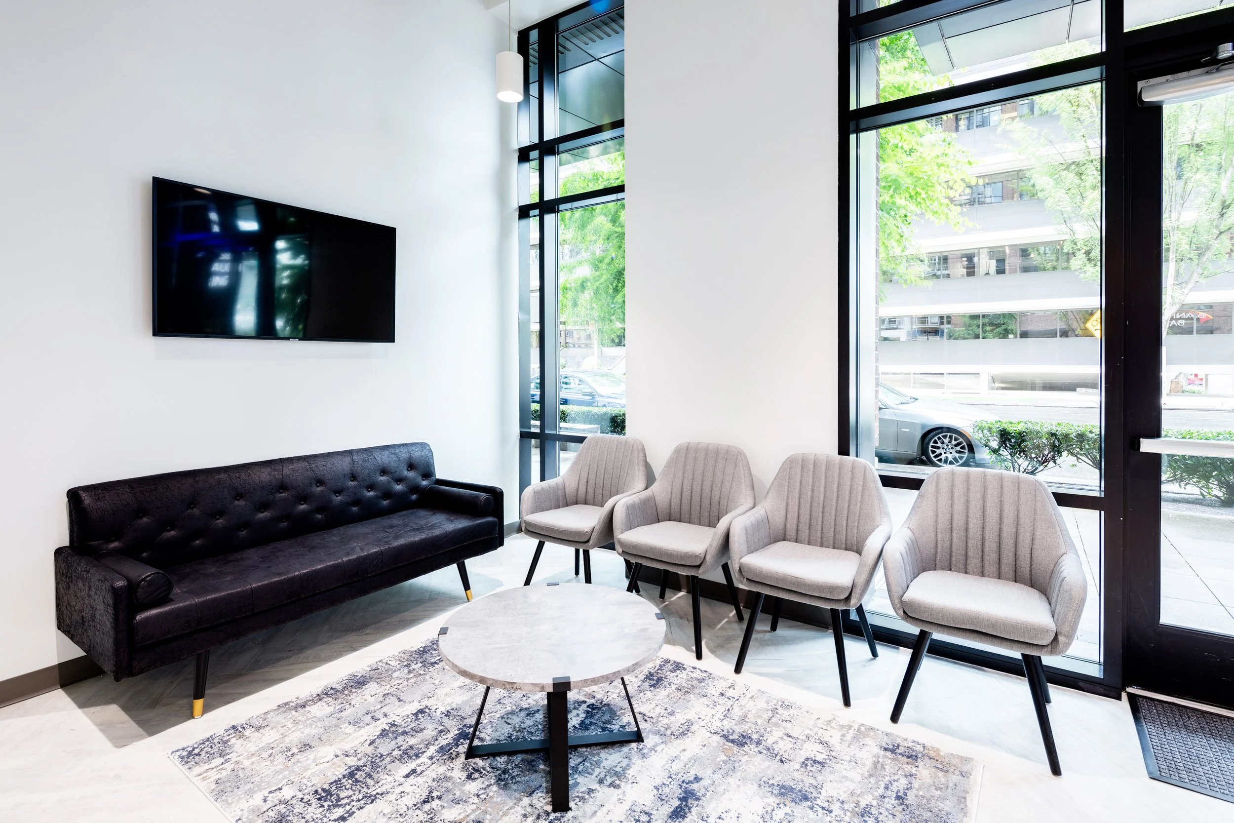 Bright waiting area at The Smile Space featuring comfortable seating, floor-to-ceiling windows, and a welcoming space for patients and families.