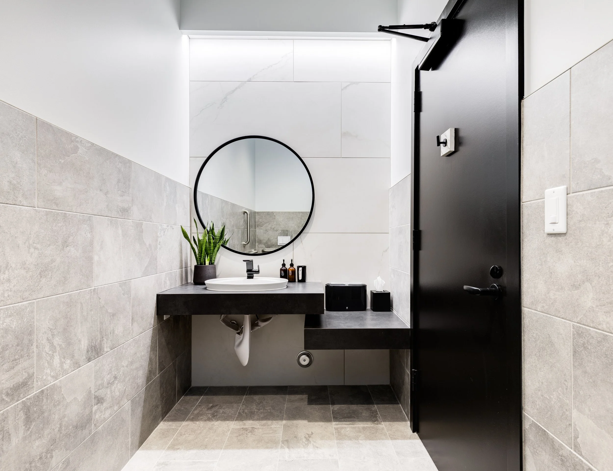 Modern patient restroom at The Smile Space featuring contemporary finishes, a floating vanity, and a bright, clean design.