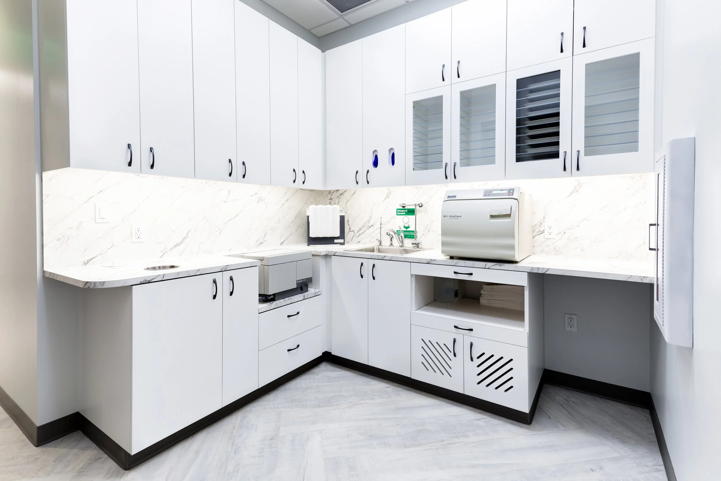 Modern dental sterilization center at The Smile Space featuring organized cabinetry, dedicated instrument processing equipment, and a clean clinical workspace.