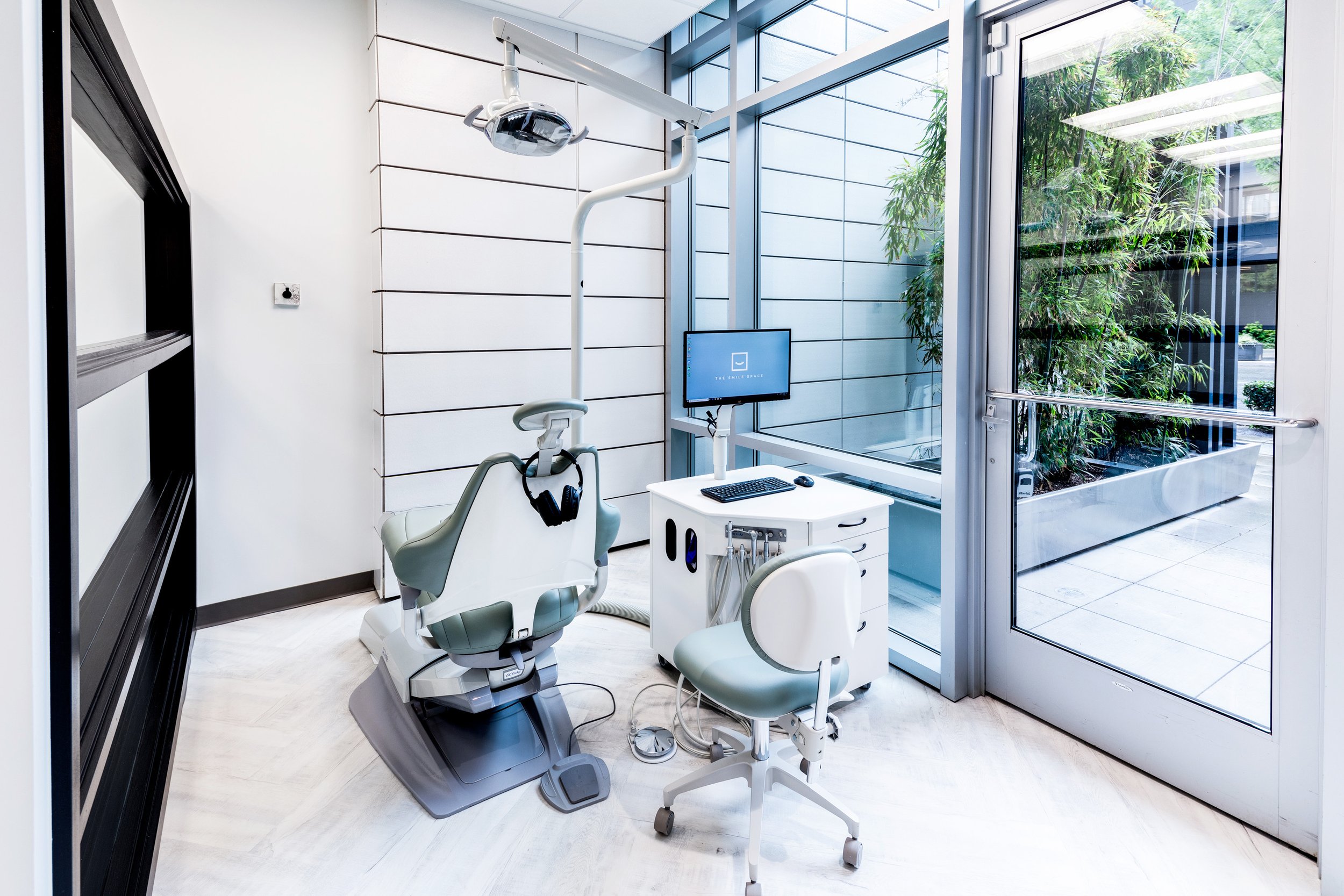 Modern dental treatment room at The Smile Space featuring a comfortable patient chair, large windows, and abundant natural light.