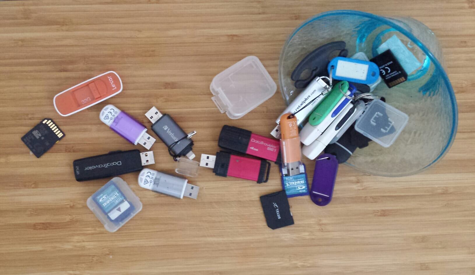 scattered mess of usb sticks, sd cards, cds, dvds, digital devices