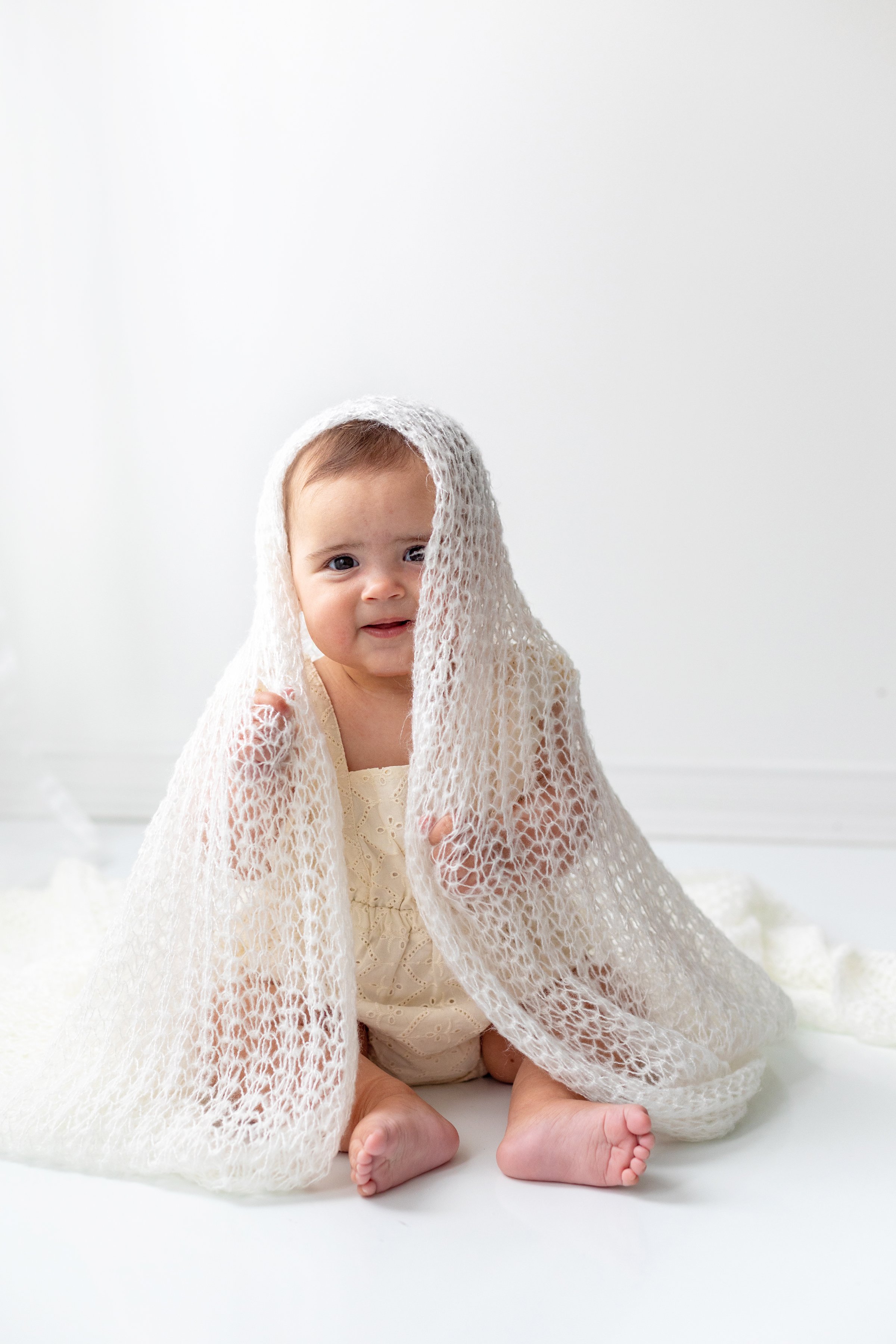 Baby girl peek a boo with blanket