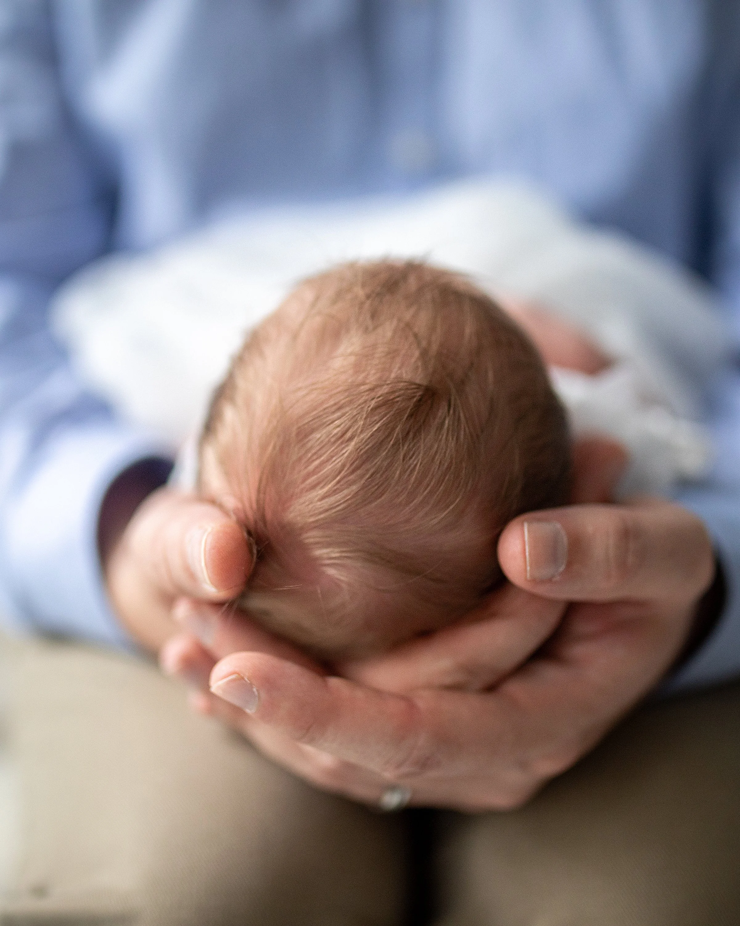 Dad holding newborn daughter's head in his hands in baby studio in Oshawa Durham Region