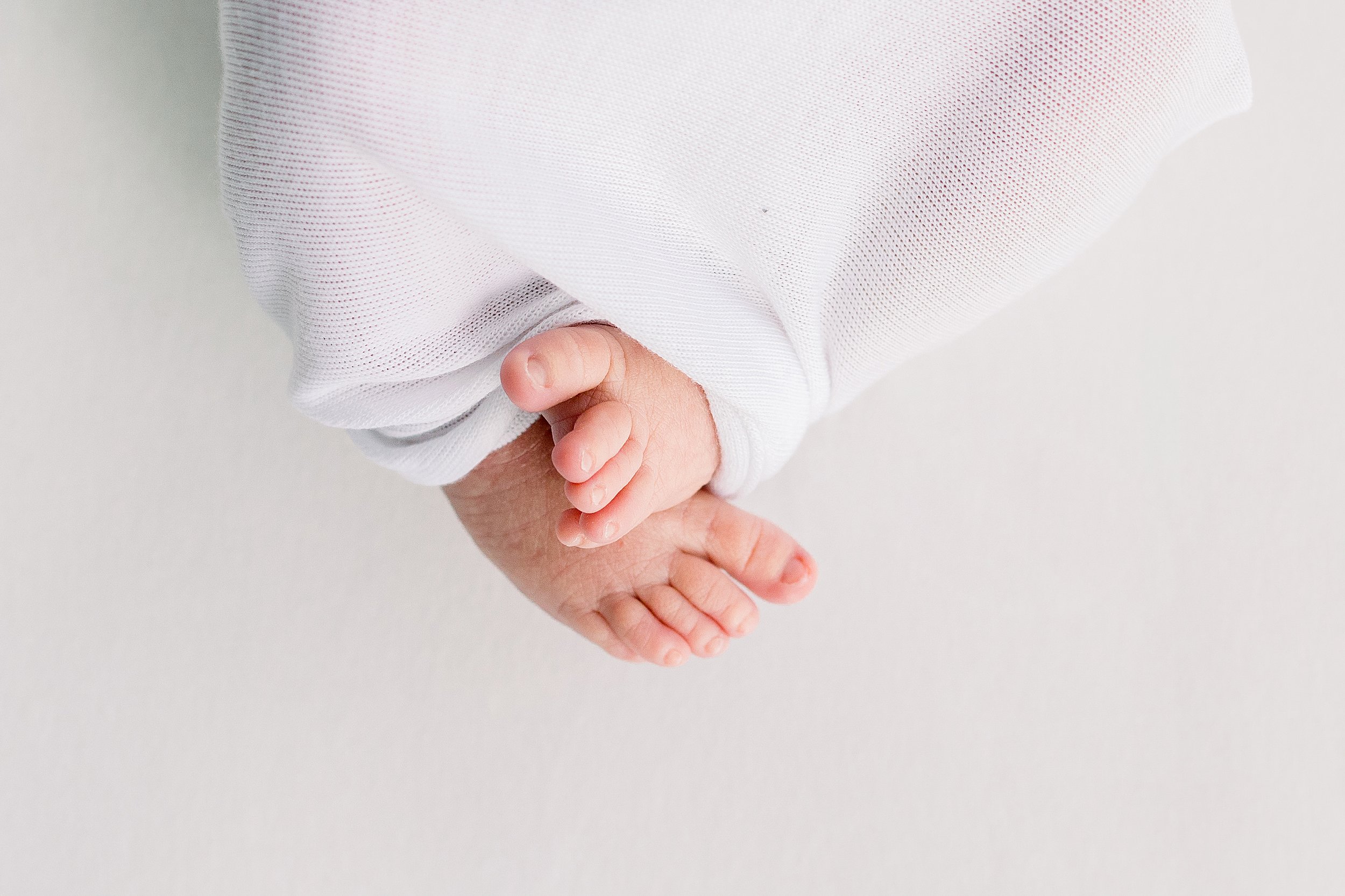 Newborn Baby Close up of toes in white swaddle