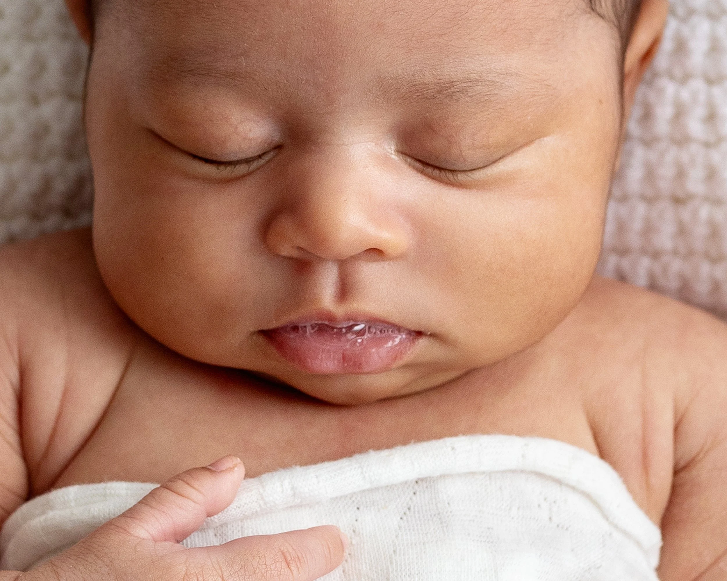 Close up of baby bubble on 3 month old's lips during newborn session in Durham Region
