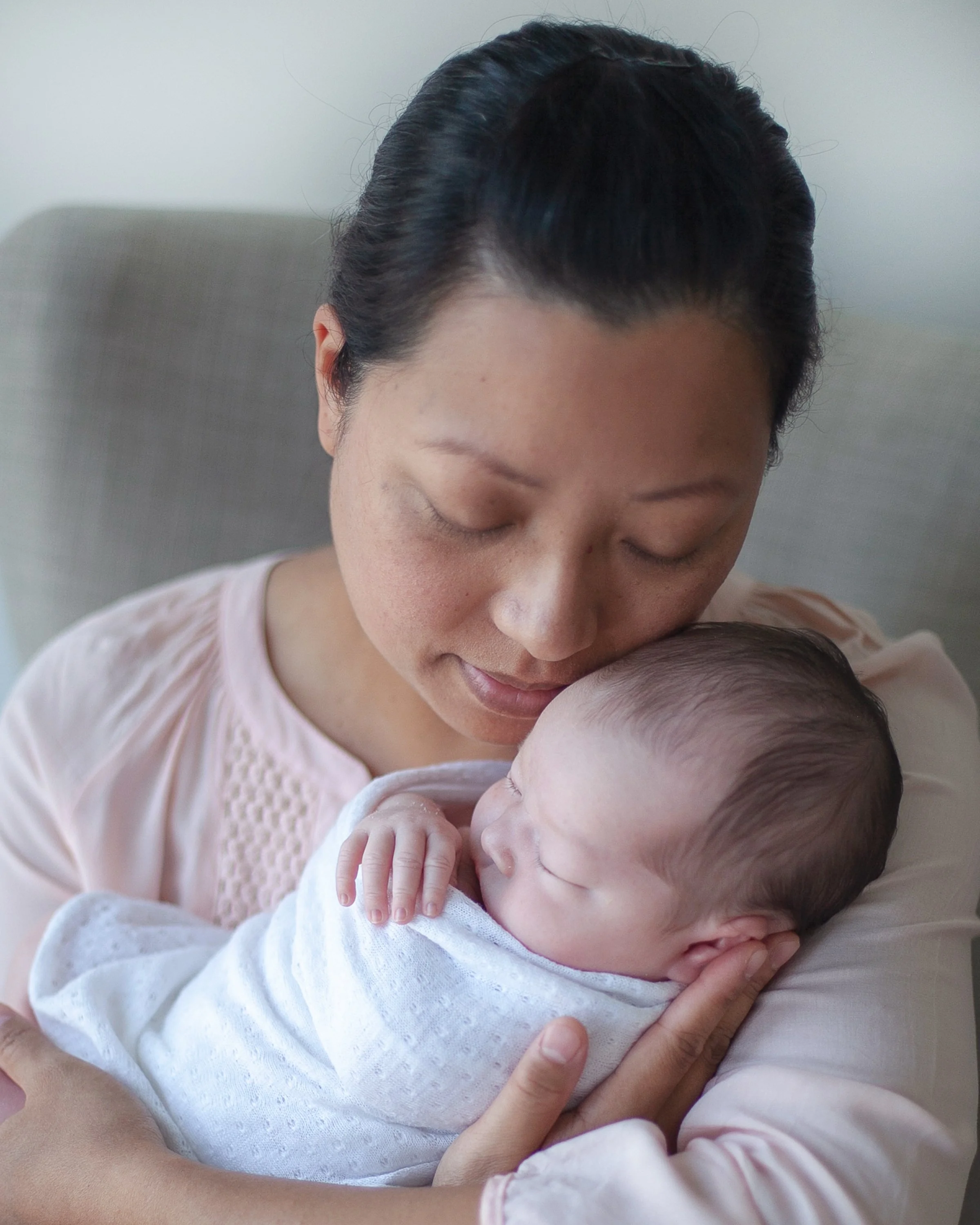 Professional newborn photography mom cuddling newborn in Durham Region