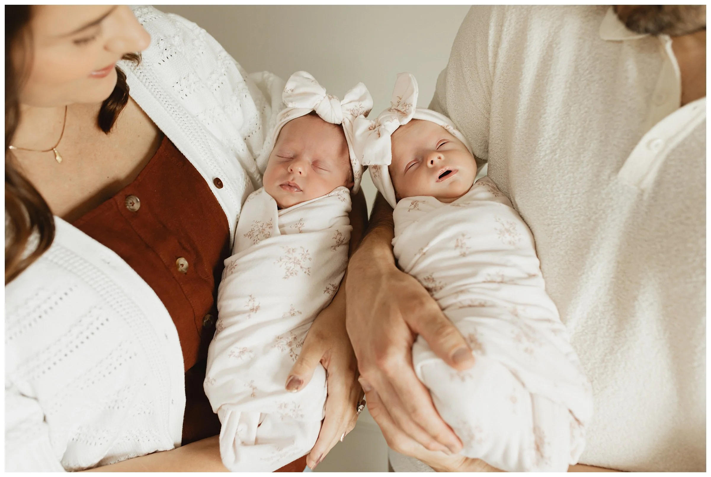  Close-up of newborn twins wrapped in neutral blankets during an in-home session  