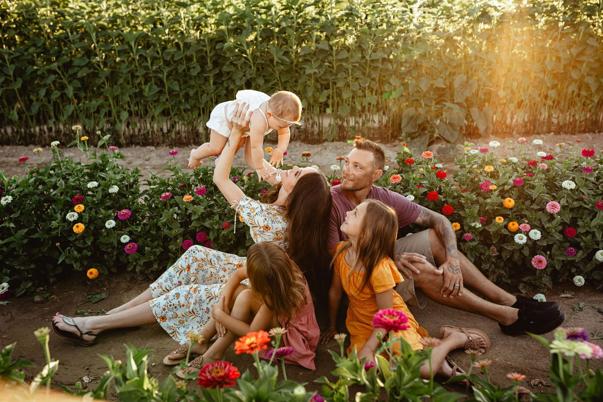 Family of five sitting in rows of flowers at a flower farm