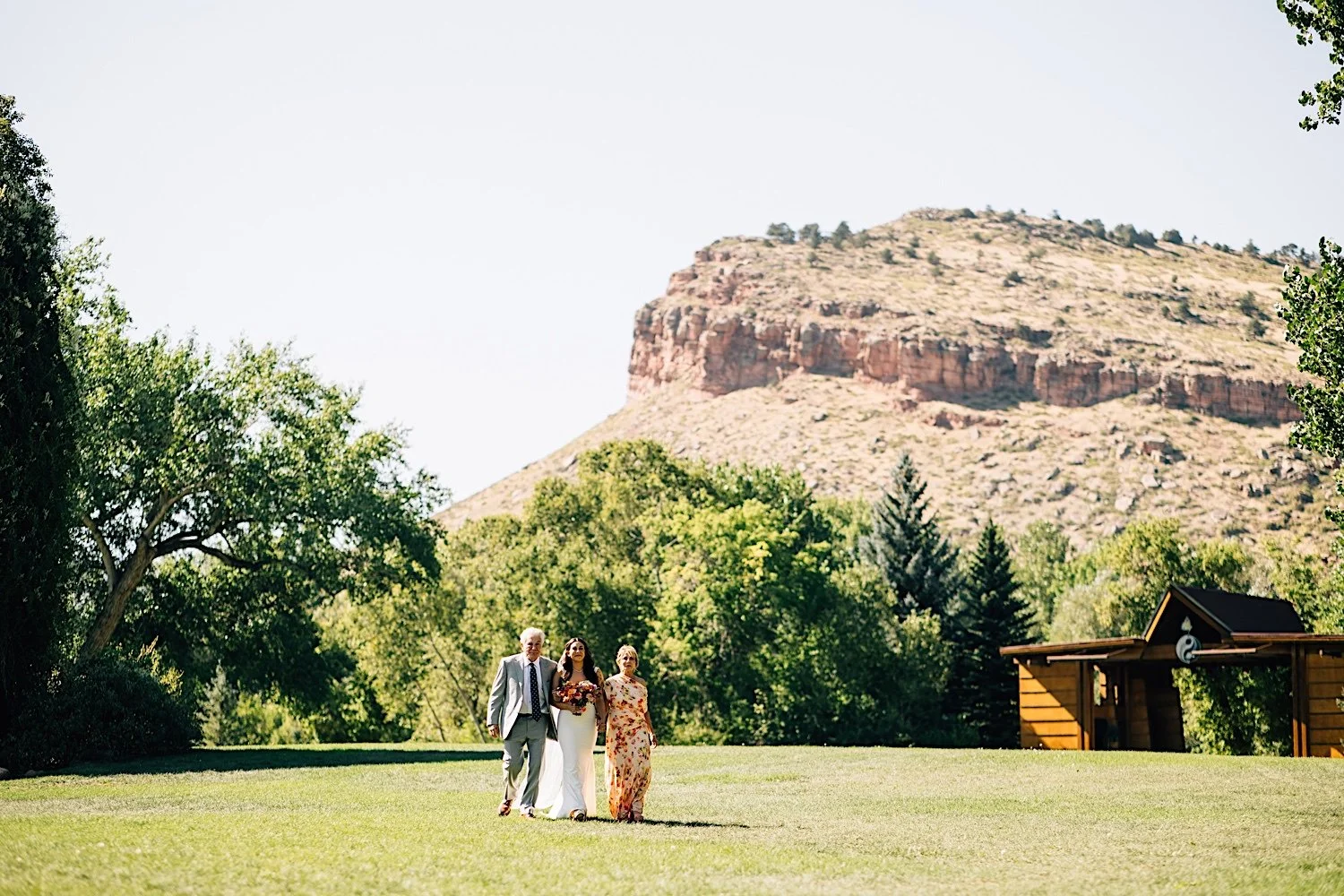 039_bride-walks-with-parents-to-wedding-ceremony-at-planet-bluegrass-wedding-venue.jpg