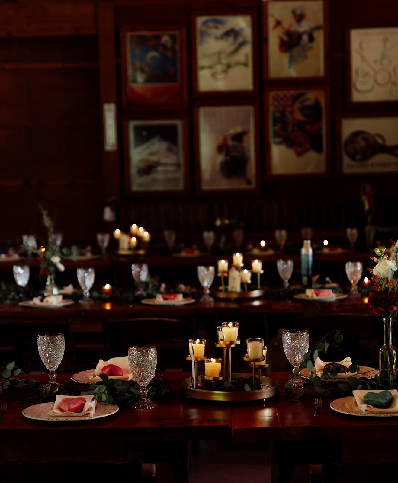 The candlelit Wildflower Pavilion at Planet Bluegrass decorated for a wedding with tables set with glassware, floral centerpieces, and candles.