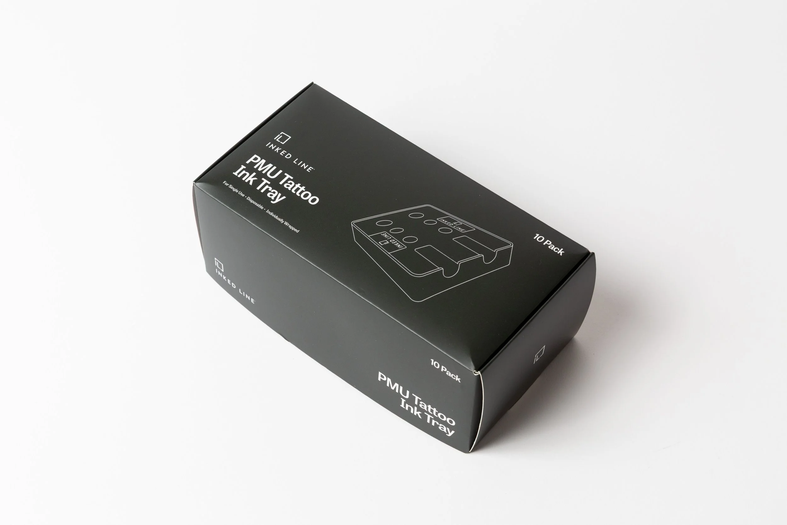 A black box labeled 'PMU Tattoo Ink Tray' from Inked Line, containing ten disposable ink trays for tattooing, on a white surface.