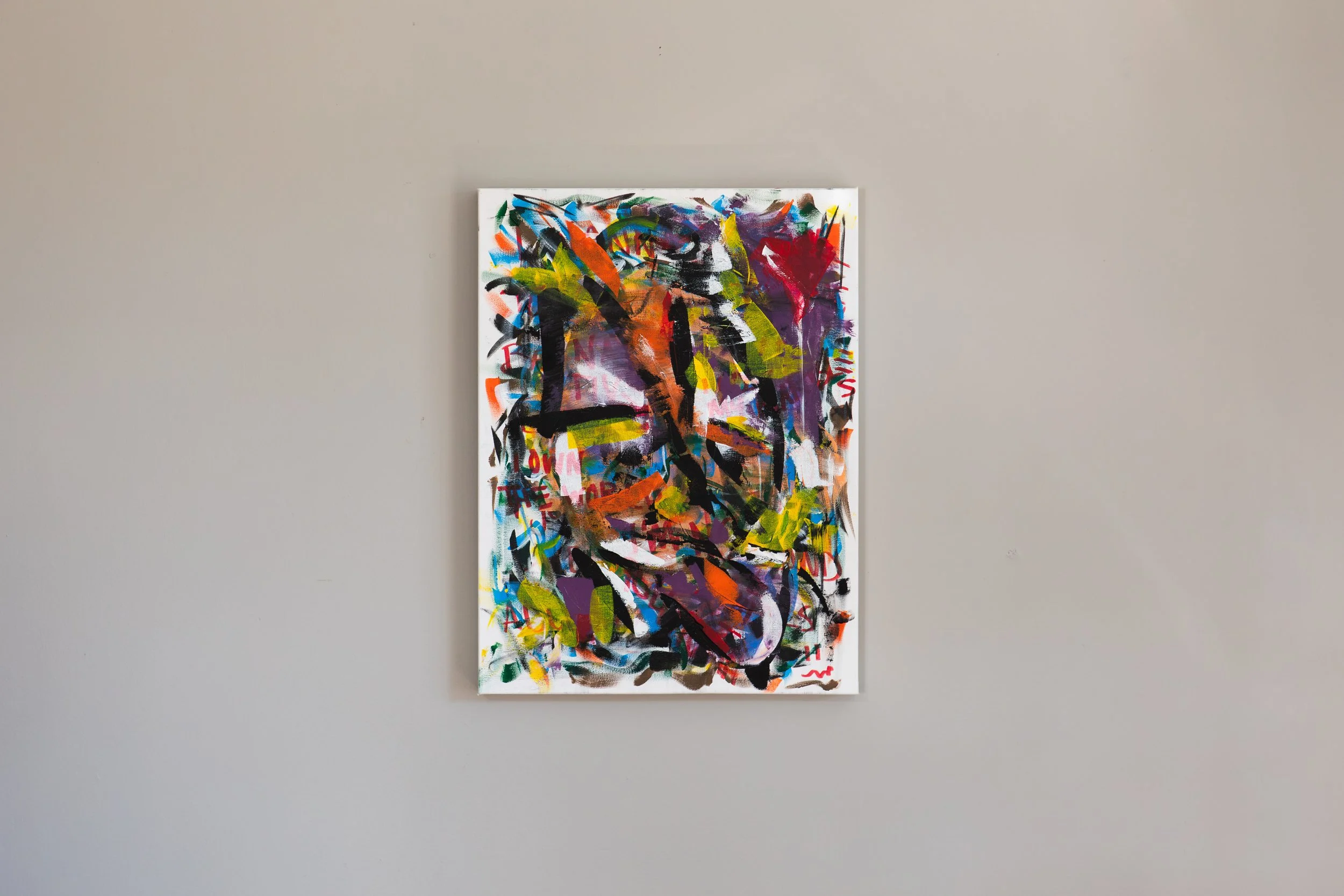 An abstract painting with vibrant colors and dynamic brushstrokes hanging on a plain gray wall.