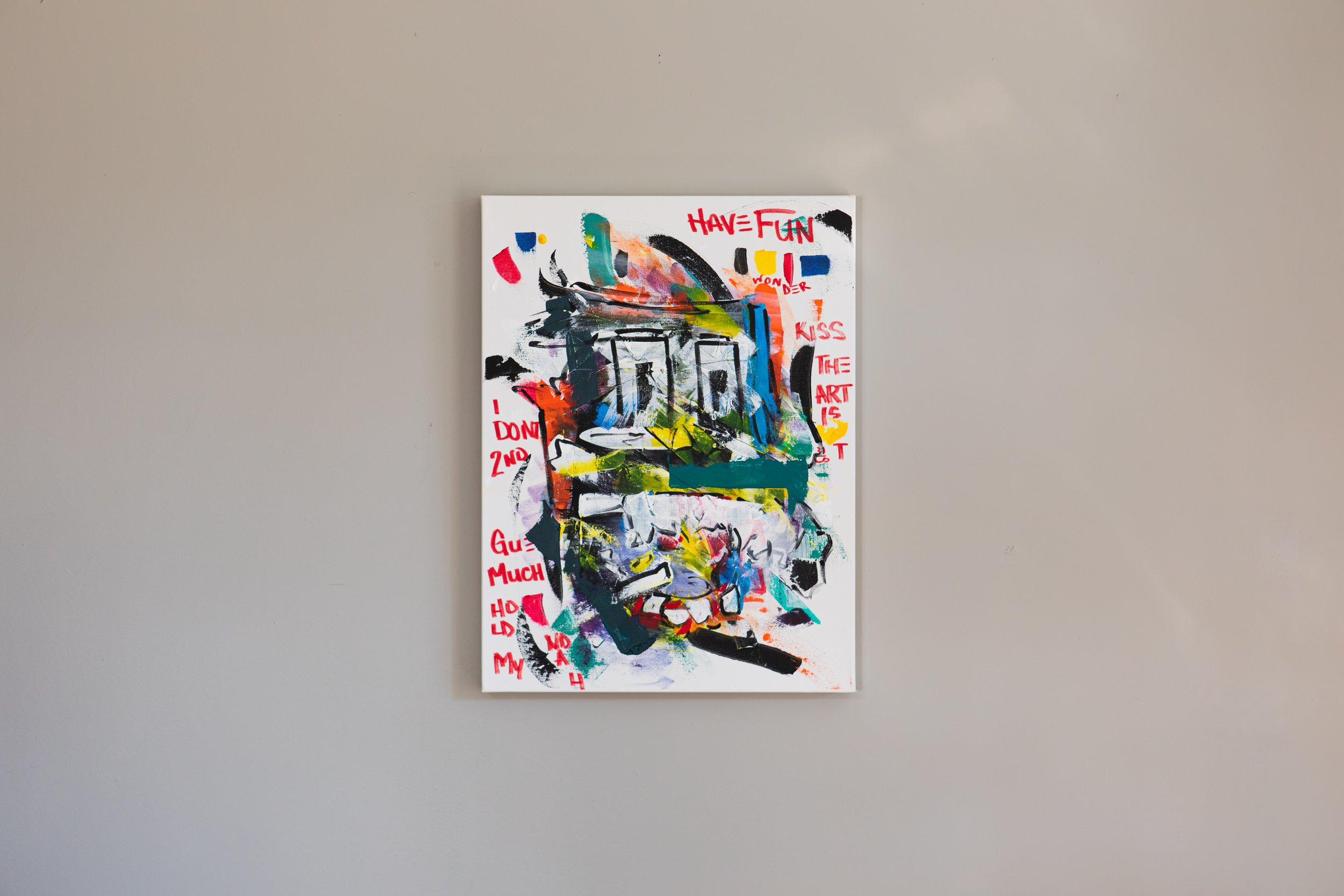 Abstract art painting with a mix of colorful brushstrokes and text on a white background. The text includes phrases like 'HAVE FUN', 'KISS THE ART', and 'I DON'T KNOW', written in red. The artwork appears to be expressive and energetic.