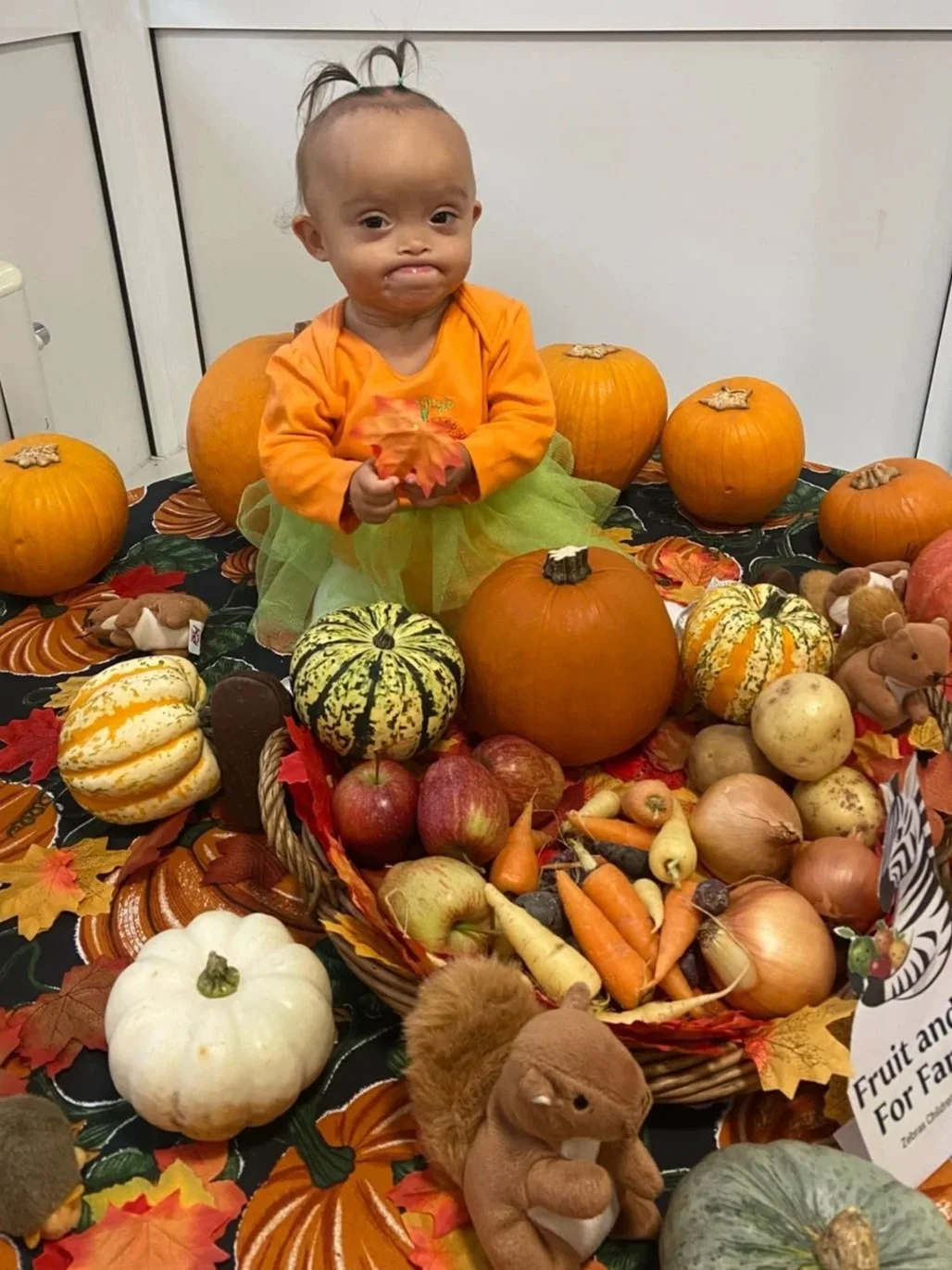 A child sitting among vegetables