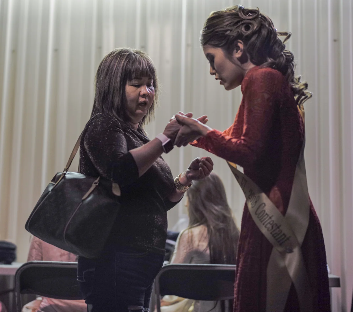 Nhung Hồng Phan shares a moment of prayer with her mother backstage moments before the show began.