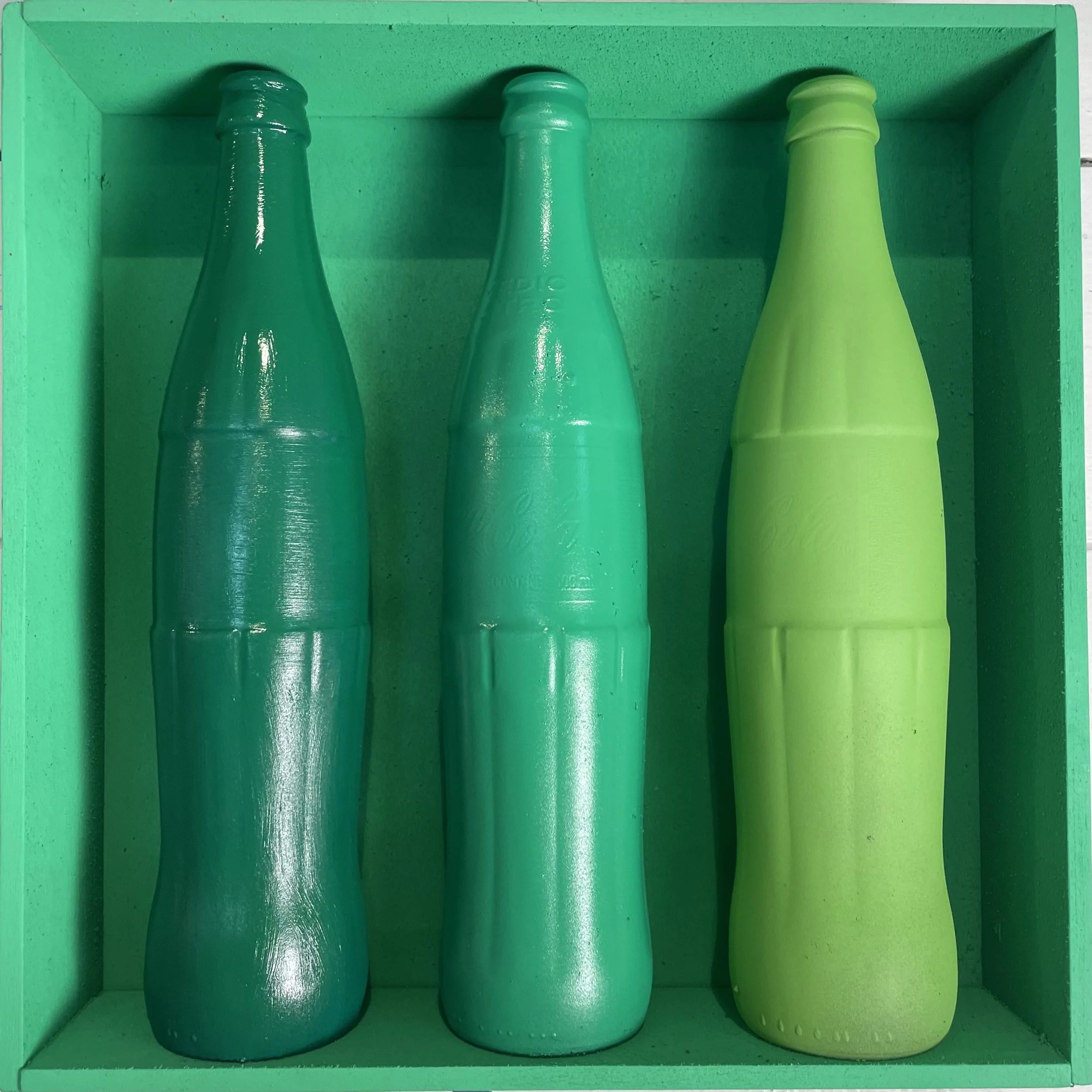  “Threesome: Green” Three painted Mexican Coke bottles in a custom-built wall display 