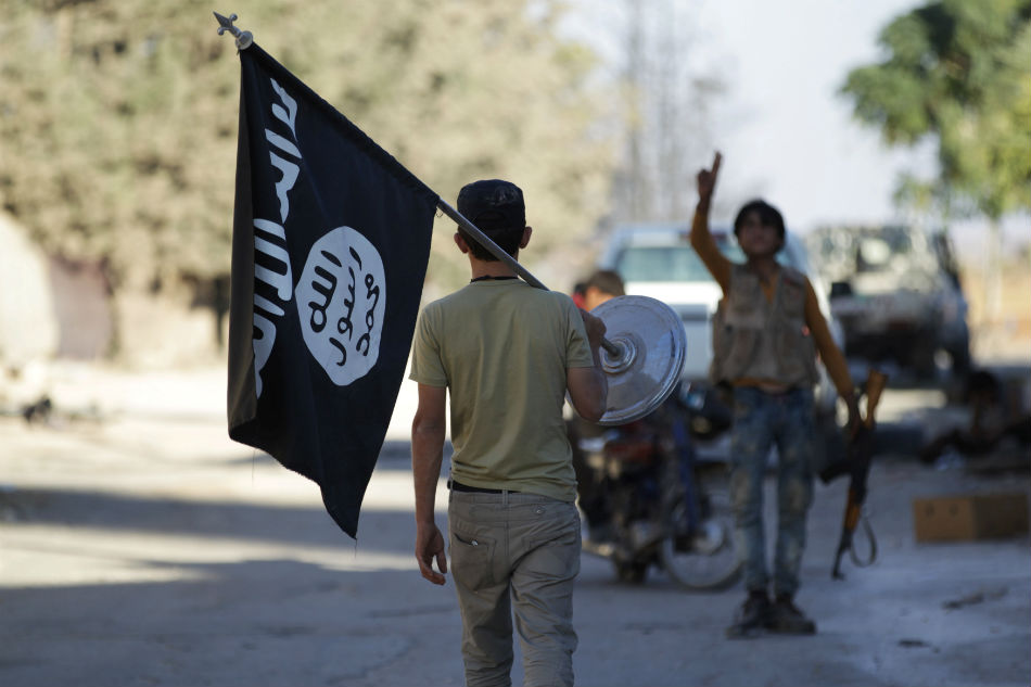A rebel fighter with the Islamic State flag in northern Aleppo Governorate, Syria ( REUTERS/Khalil Ashawi)