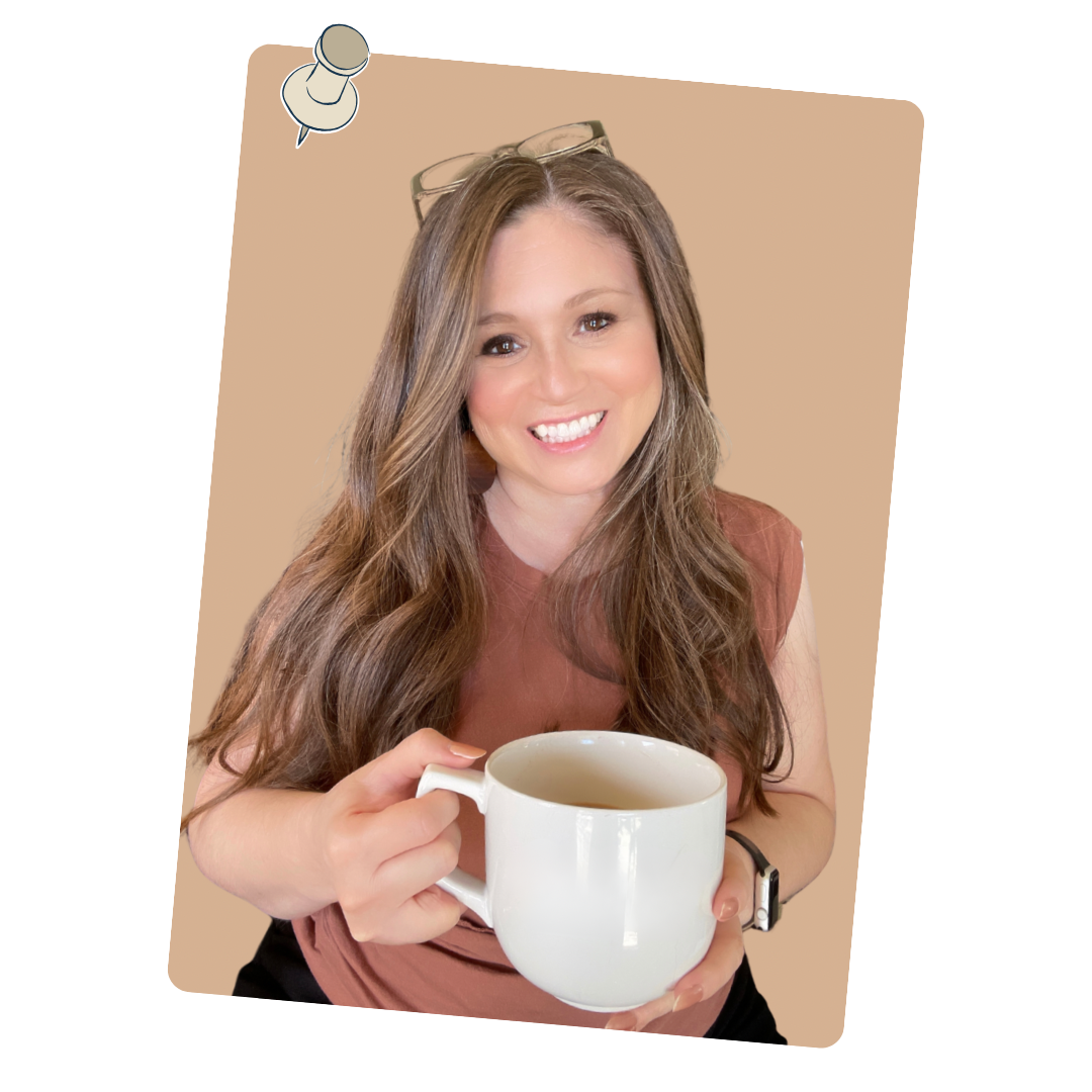 A smiling woman with long brown hair wearing a reddish-brown sleeveless top, holding a white mug of tea or coffee, with glasses resting on her head.